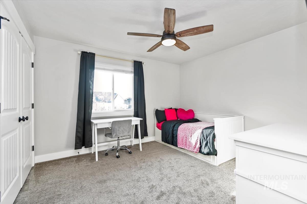 Bedroom featuring light colored carpet and a ceiling fan