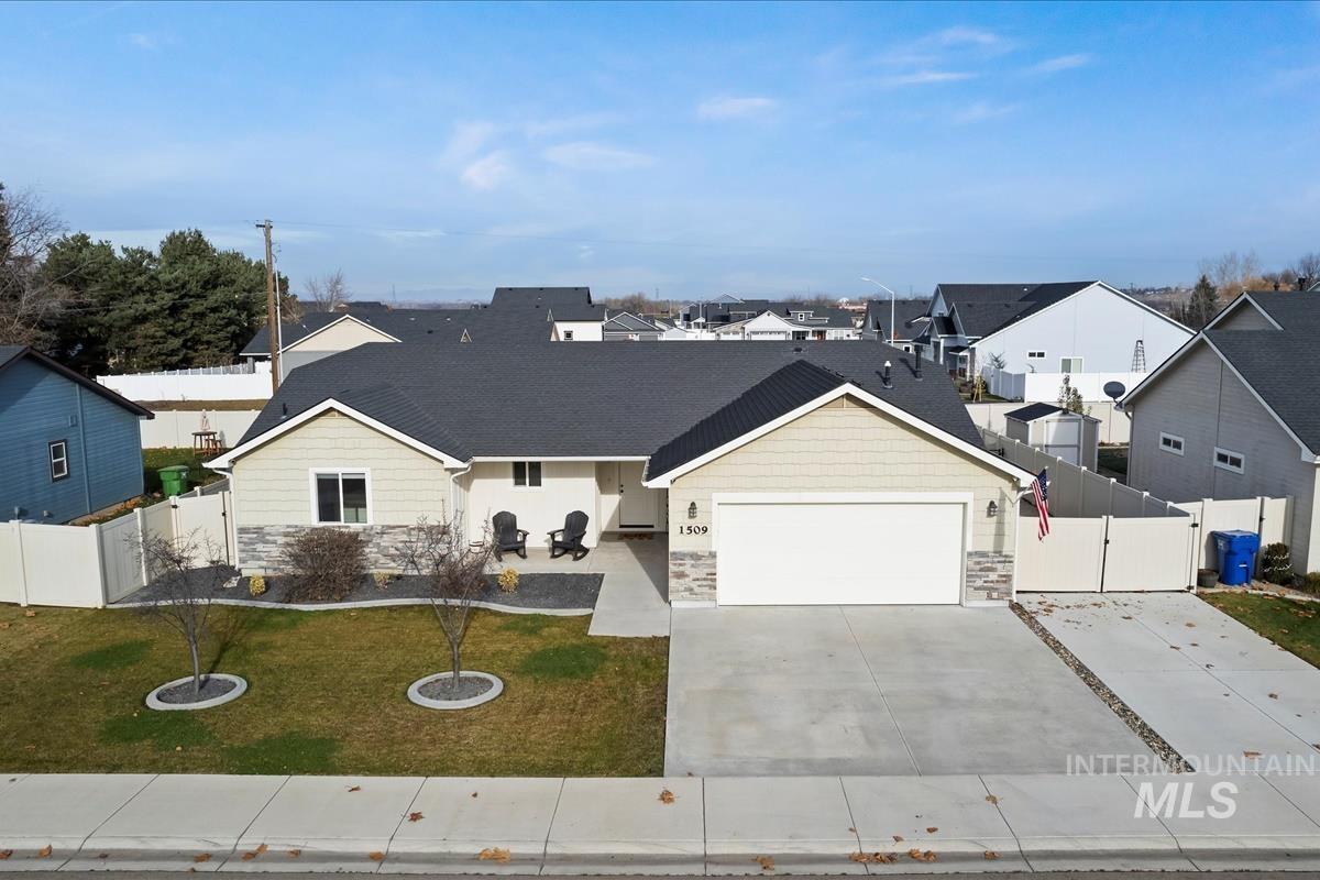 Traditional-style house with stone siding, covered porch, a residential view, concrete driveway, and a garage