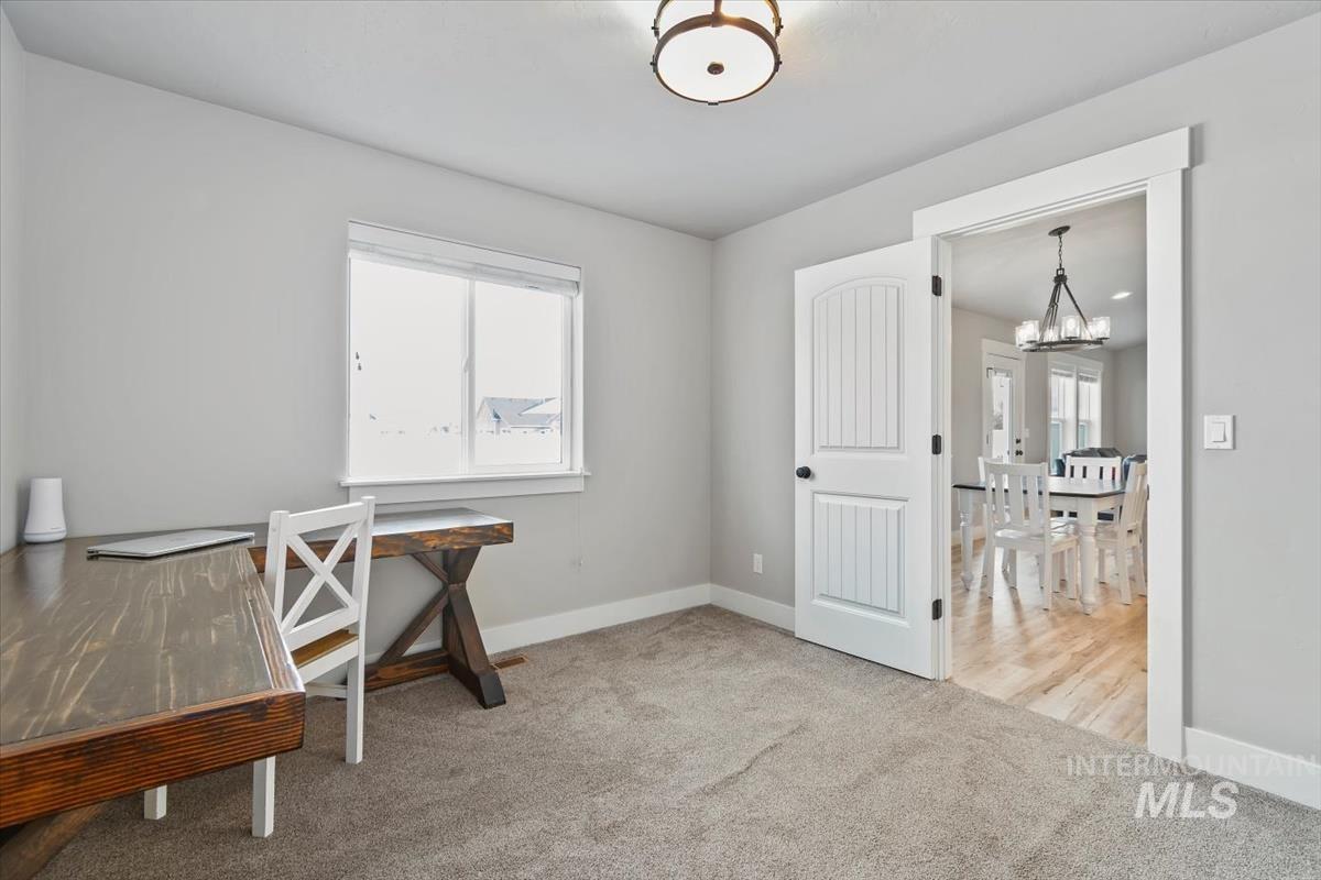 Office space featuring light colored carpet and a chandelier