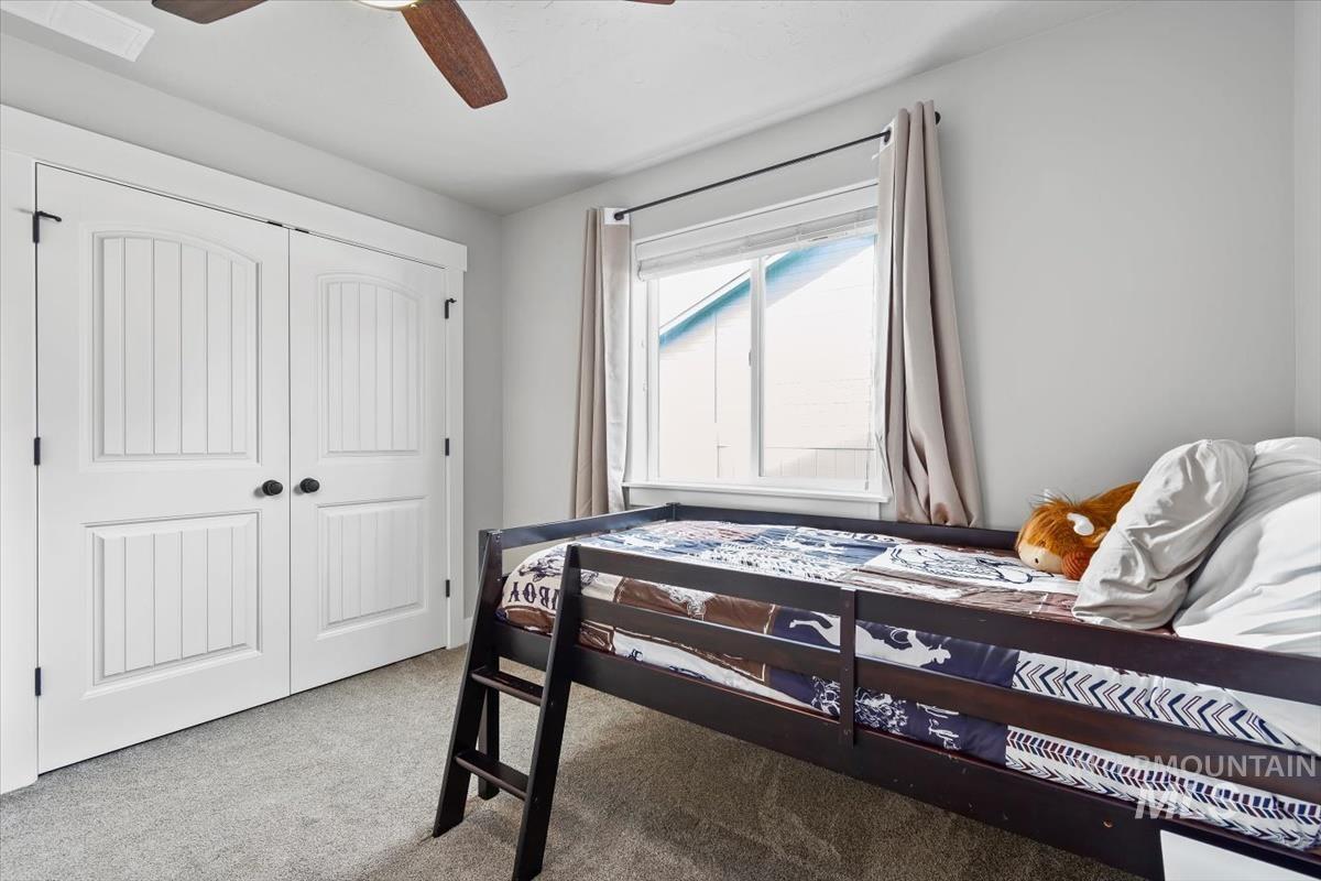 Bedroom with light carpet, a closet, and ceiling fan