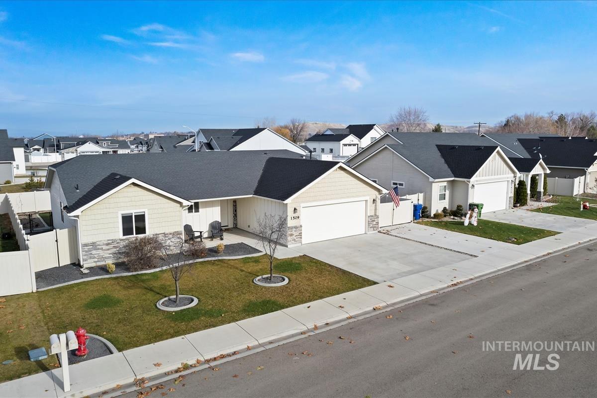 Traditional home with a residential view, stone siding, driveway, an attached garage, and a porch