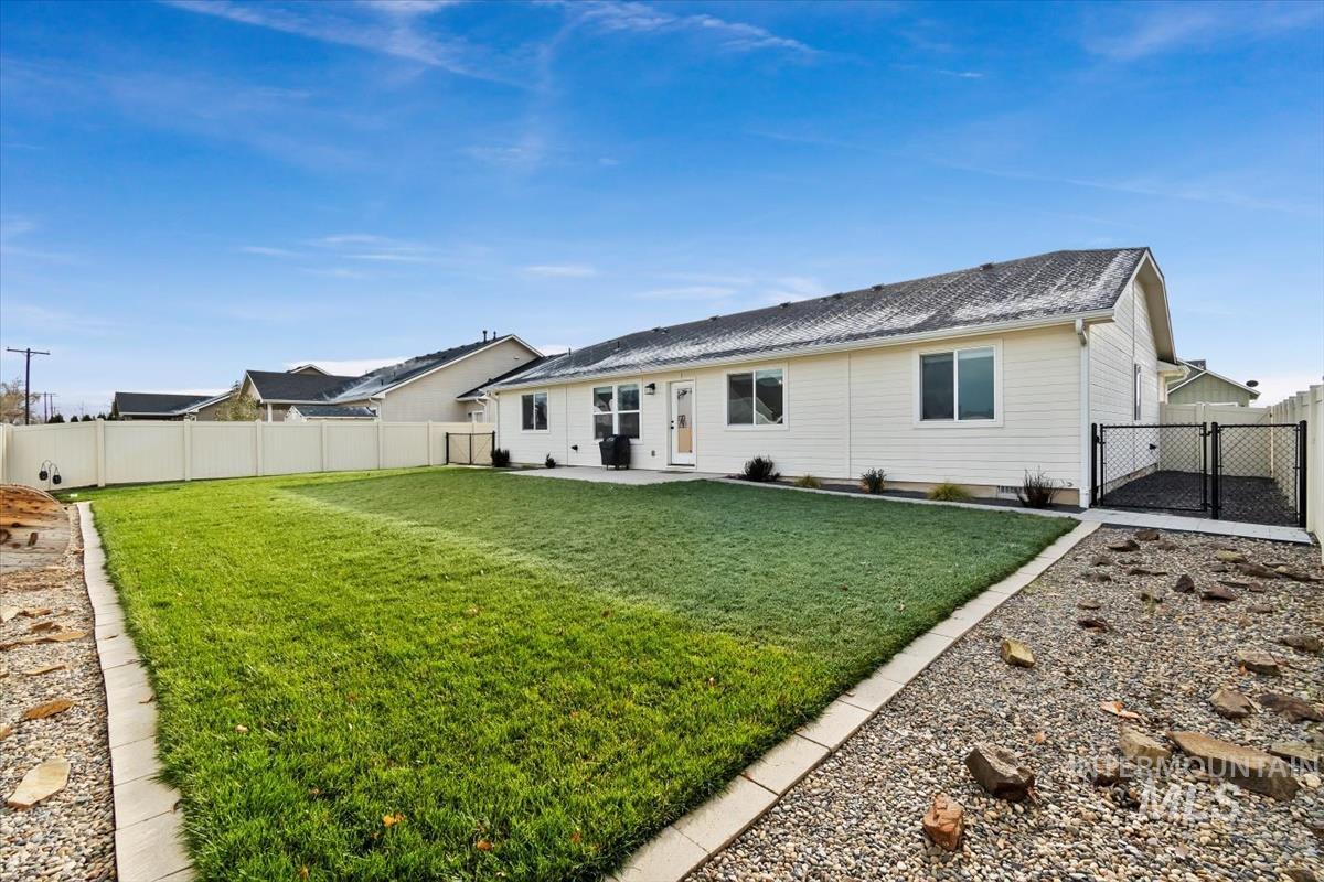 Rear view of property featuring a fenced backyard, a patio area, and a shingled roof