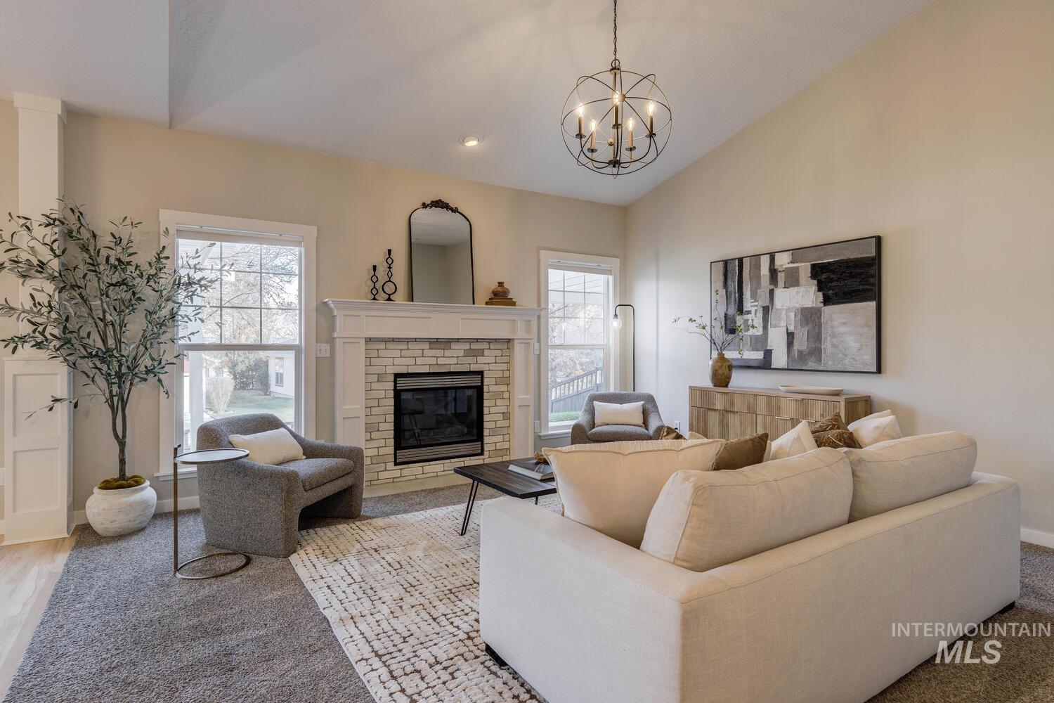 Living area with a brick fireplace, lofted ceiling, and recessed lighting