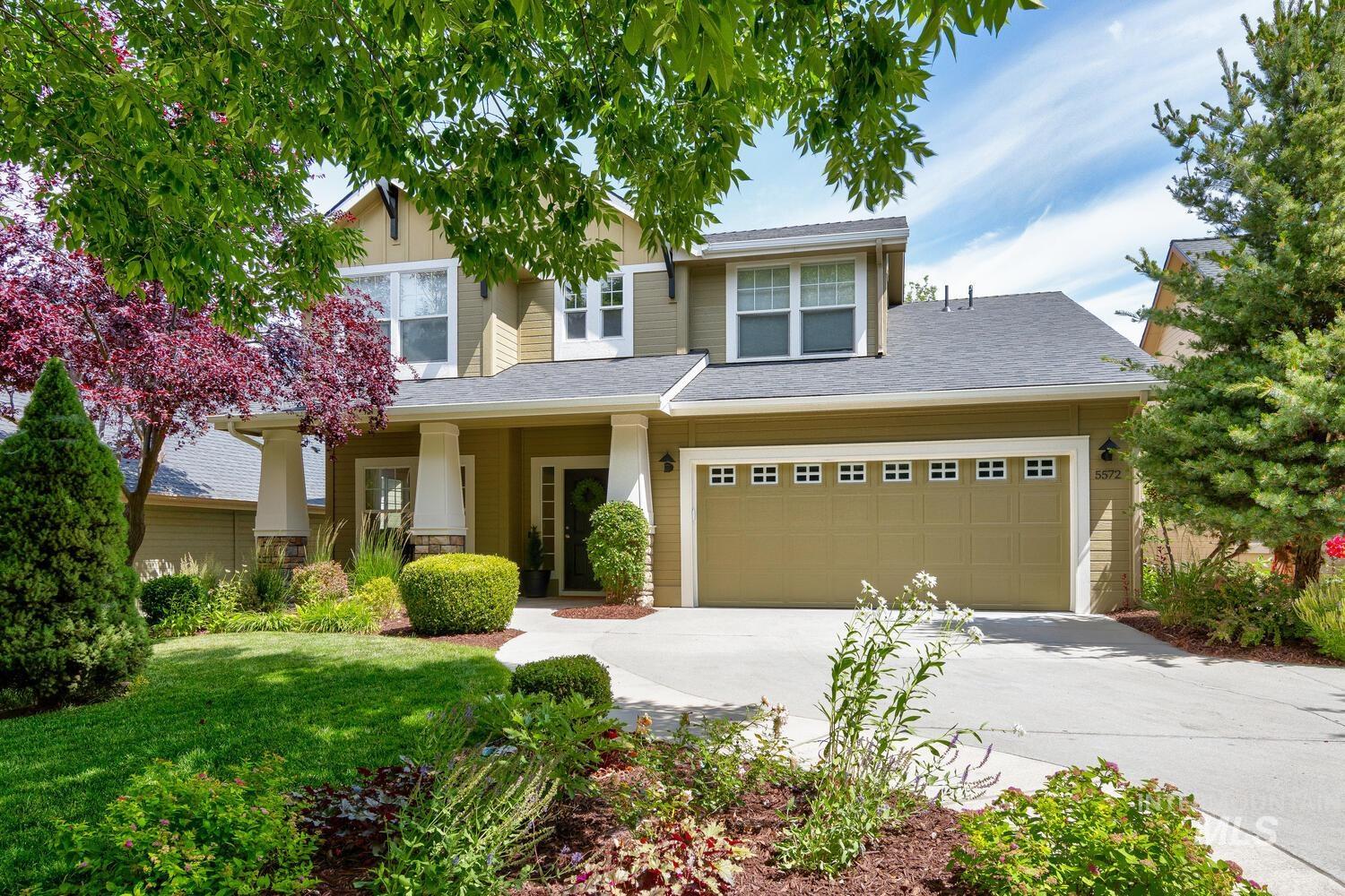 View of front of home with concrete driveway, a front yard, and an attached garage