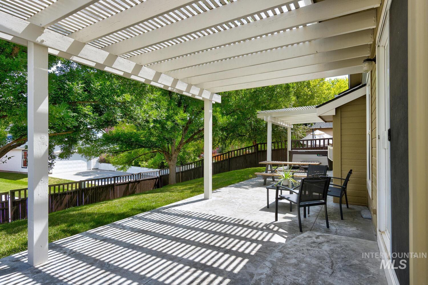 Fenced backyard featuring a pergola and a patio area