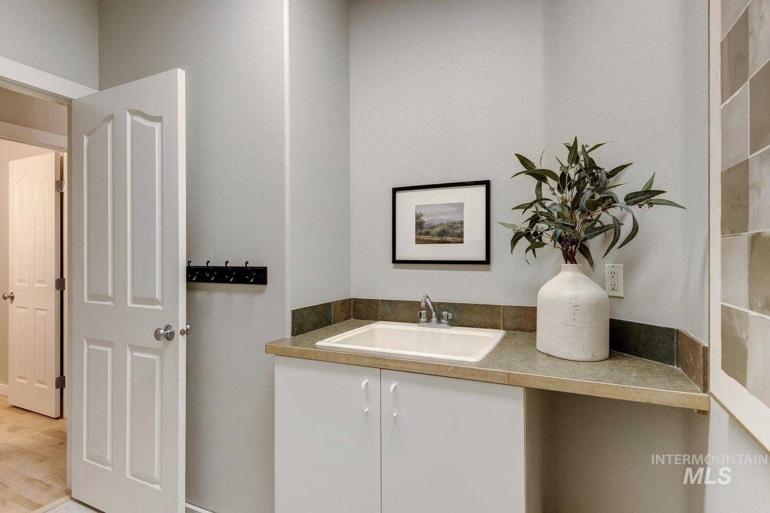 Bar area featuring white cabinetry and a sink