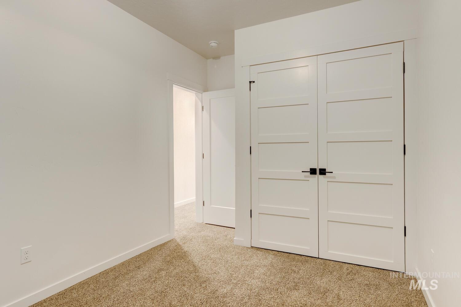 Unfurnished bedroom with light carpet and a closet