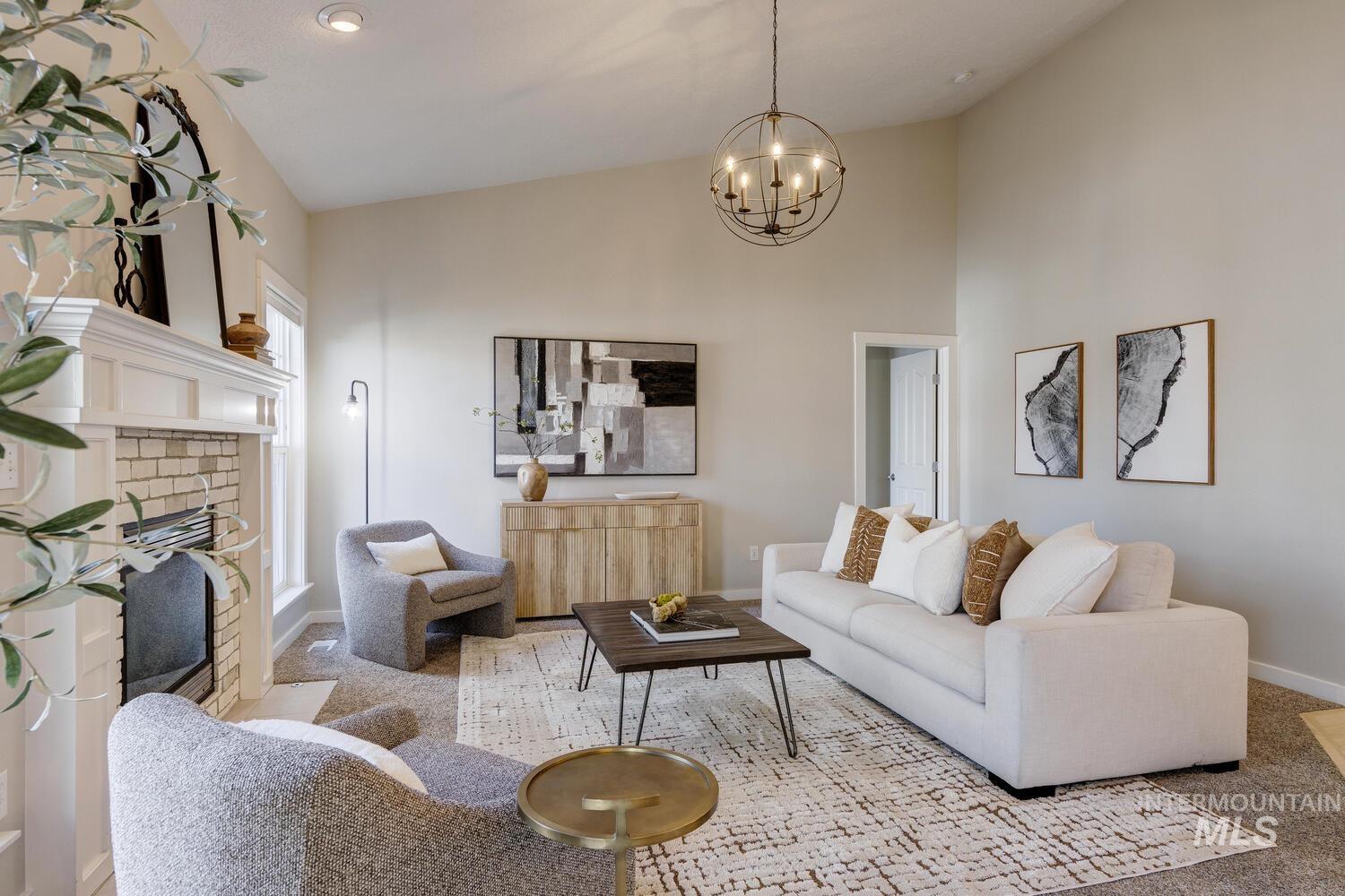 Living area with high vaulted ceiling, a fireplace, a chandelier, and carpet