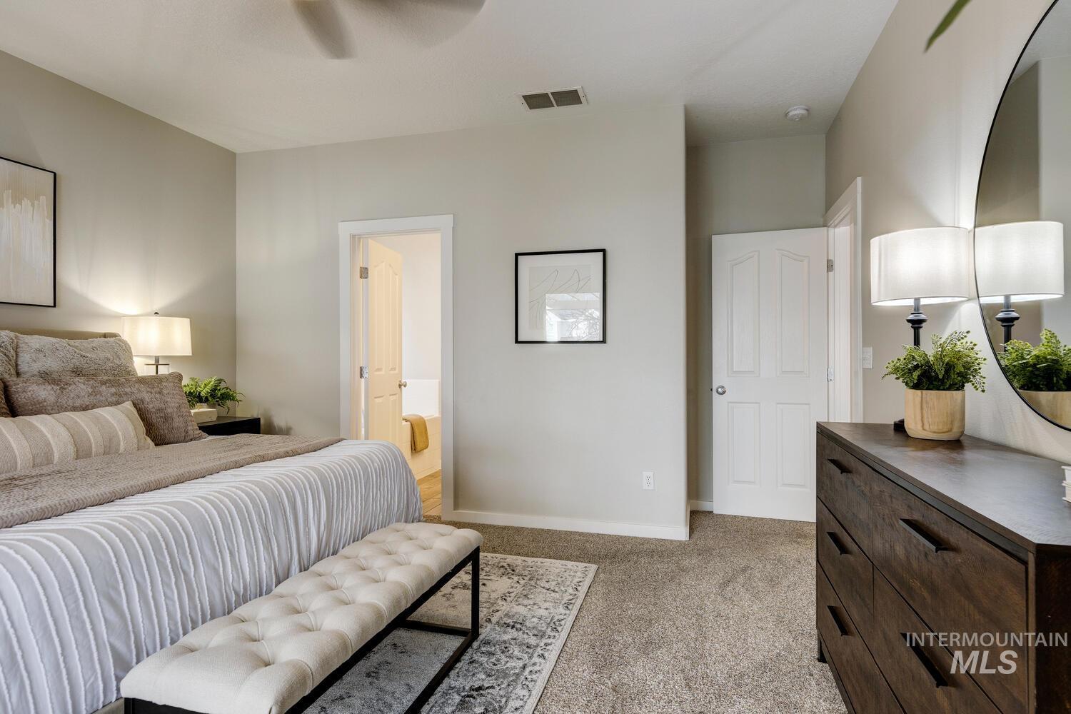 Bedroom featuring connected bathroom, light colored carpet, and a ceiling fan