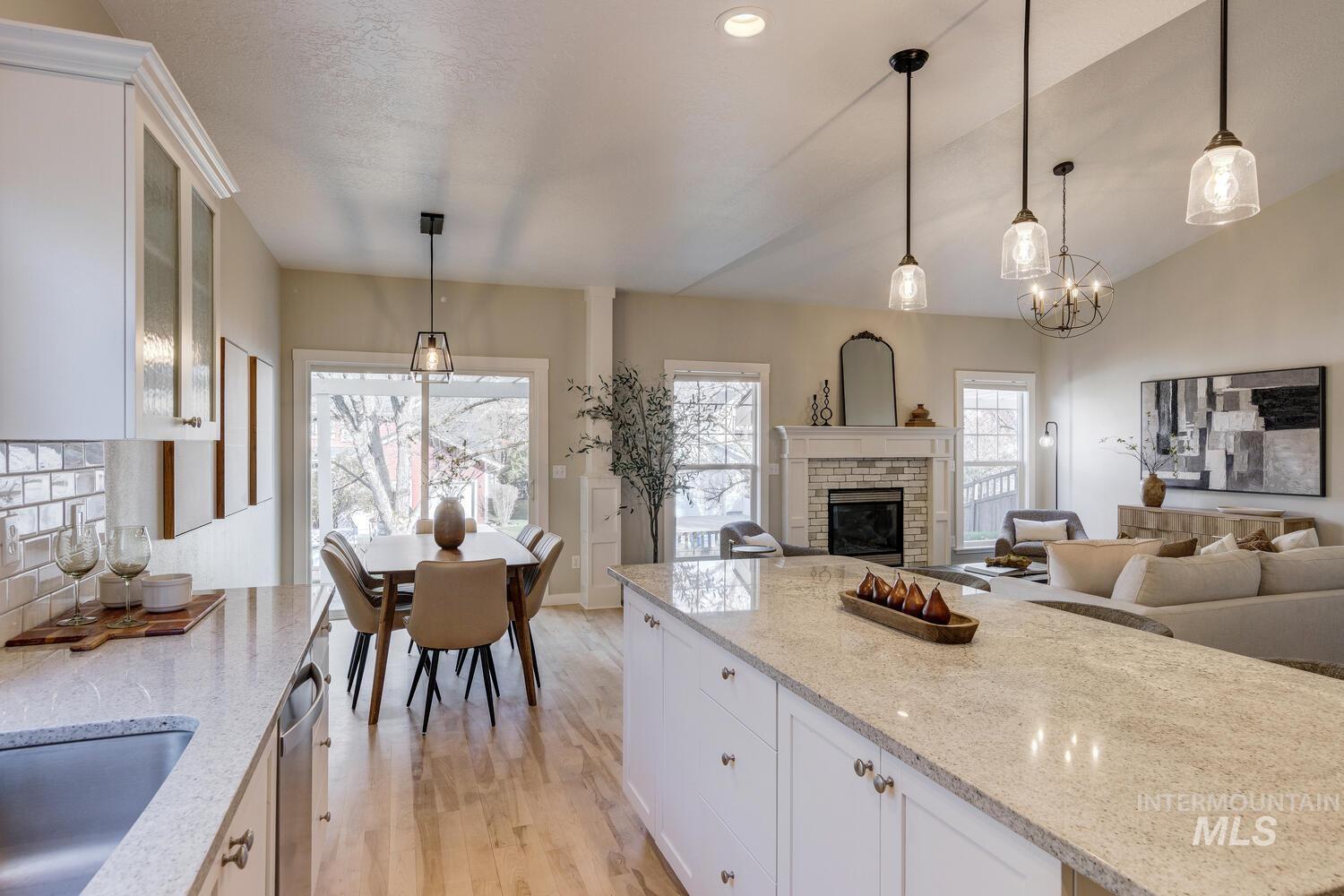 Kitchen with white cabinets, light stone counters, pendant lighting, light wood-type flooring, and recessed lighting