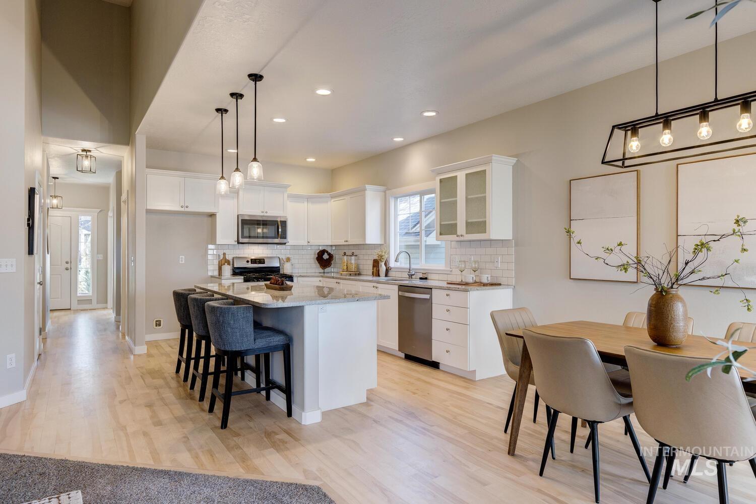 Kitchen featuring glass insert cabinets, a breakfast bar, backsplash, white cabinets, and a center island