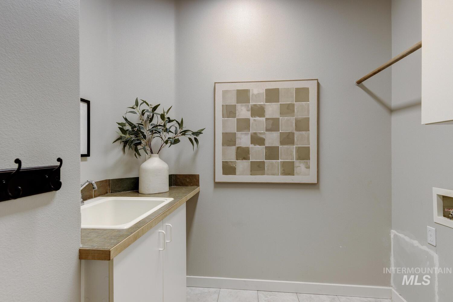 Laundry area featuring hookup for a washing machine and light tile patterned flooring