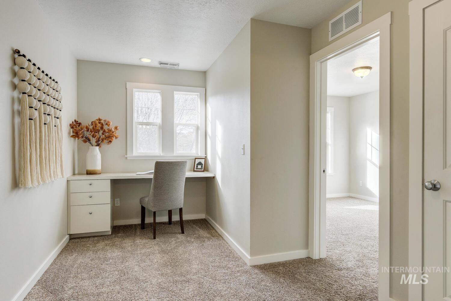 Office featuring light carpet and built in study area