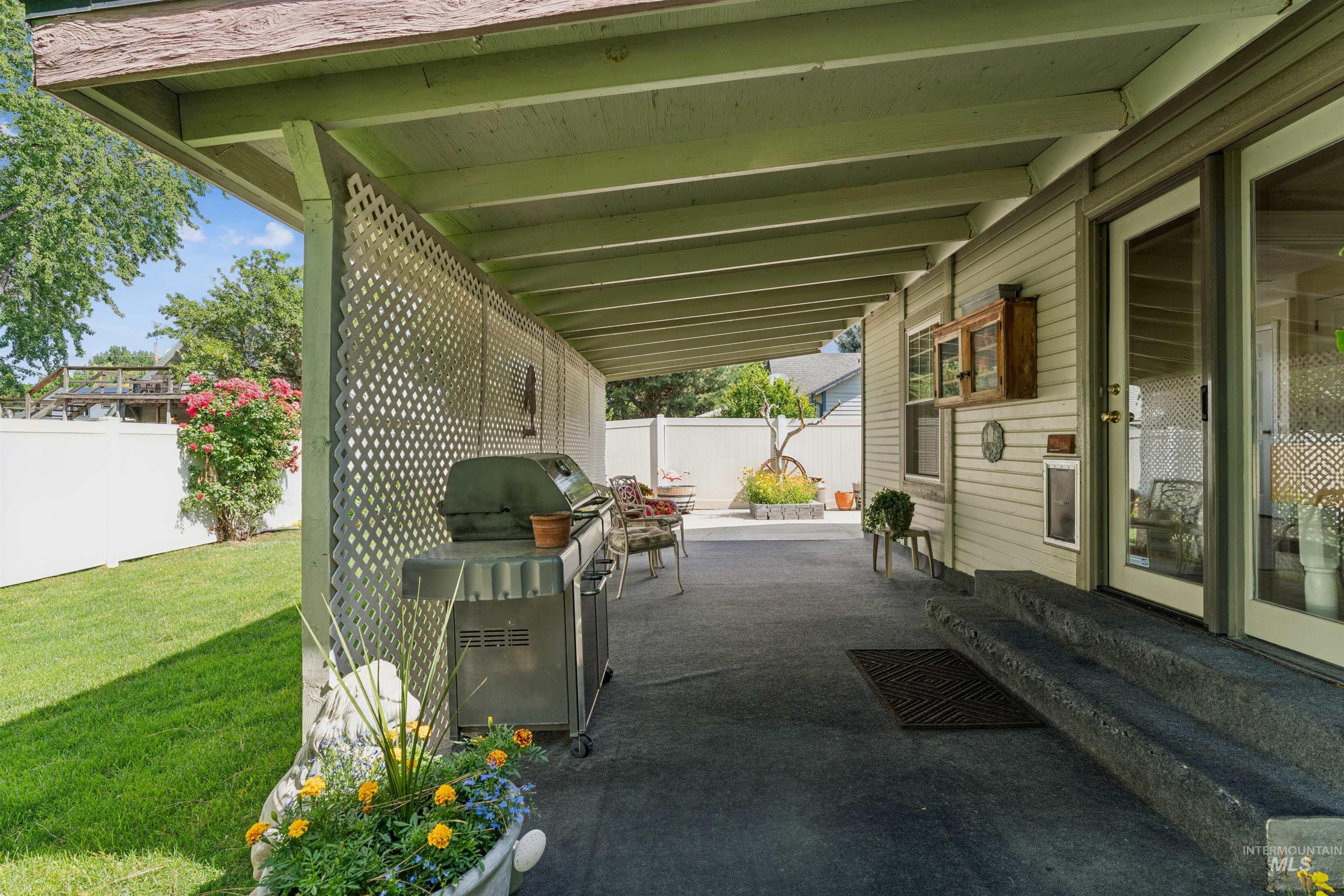 Covered patio featuring a lattice privacy screen, direct outdoor access, and a concrete surface