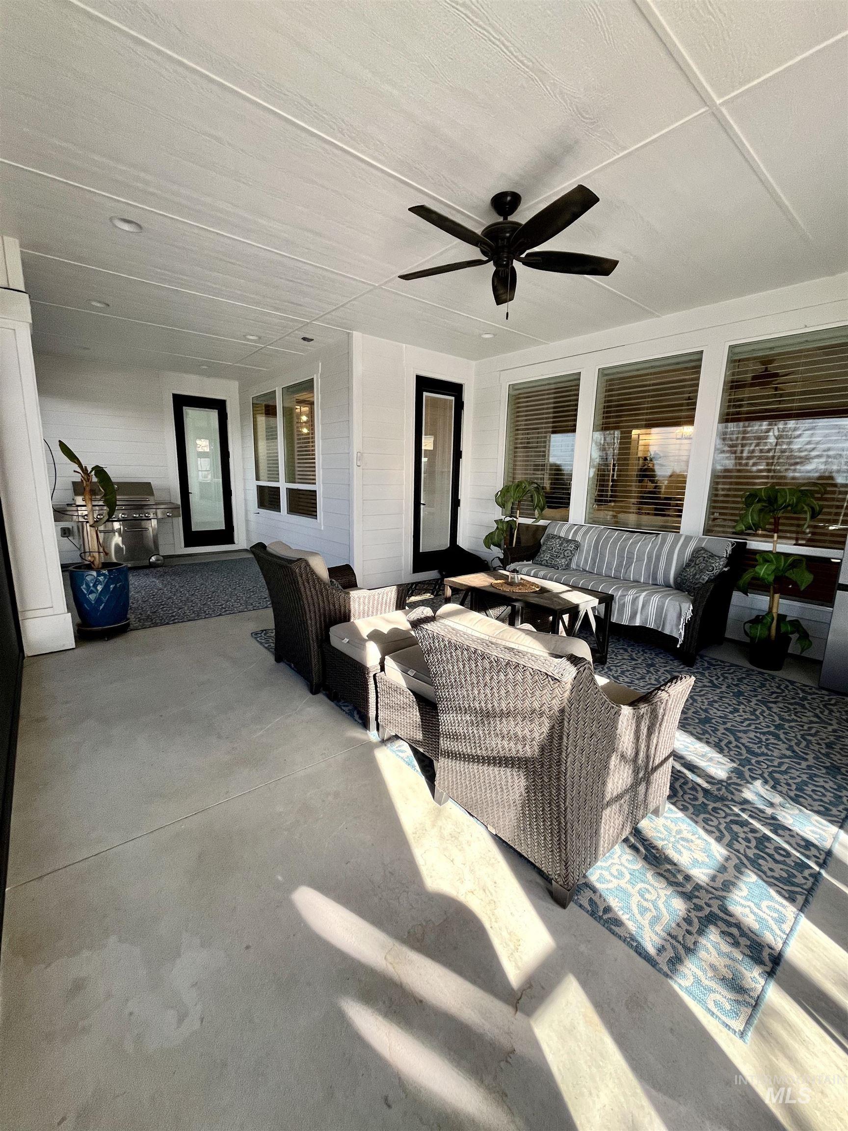 View of patio with a ceiling fan, an outdoor living space, and area for grilling