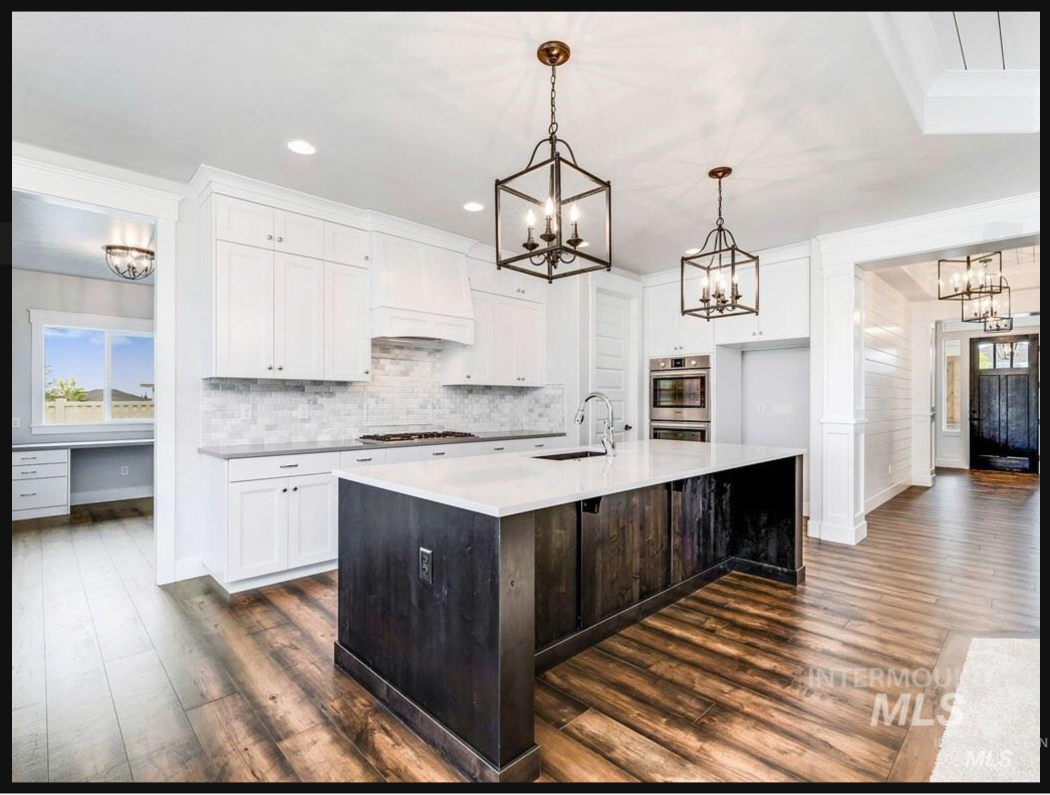 Kitchen featuring a chandelier, white cabinets, a center island with sink, pendant lighting, and recessed lighting