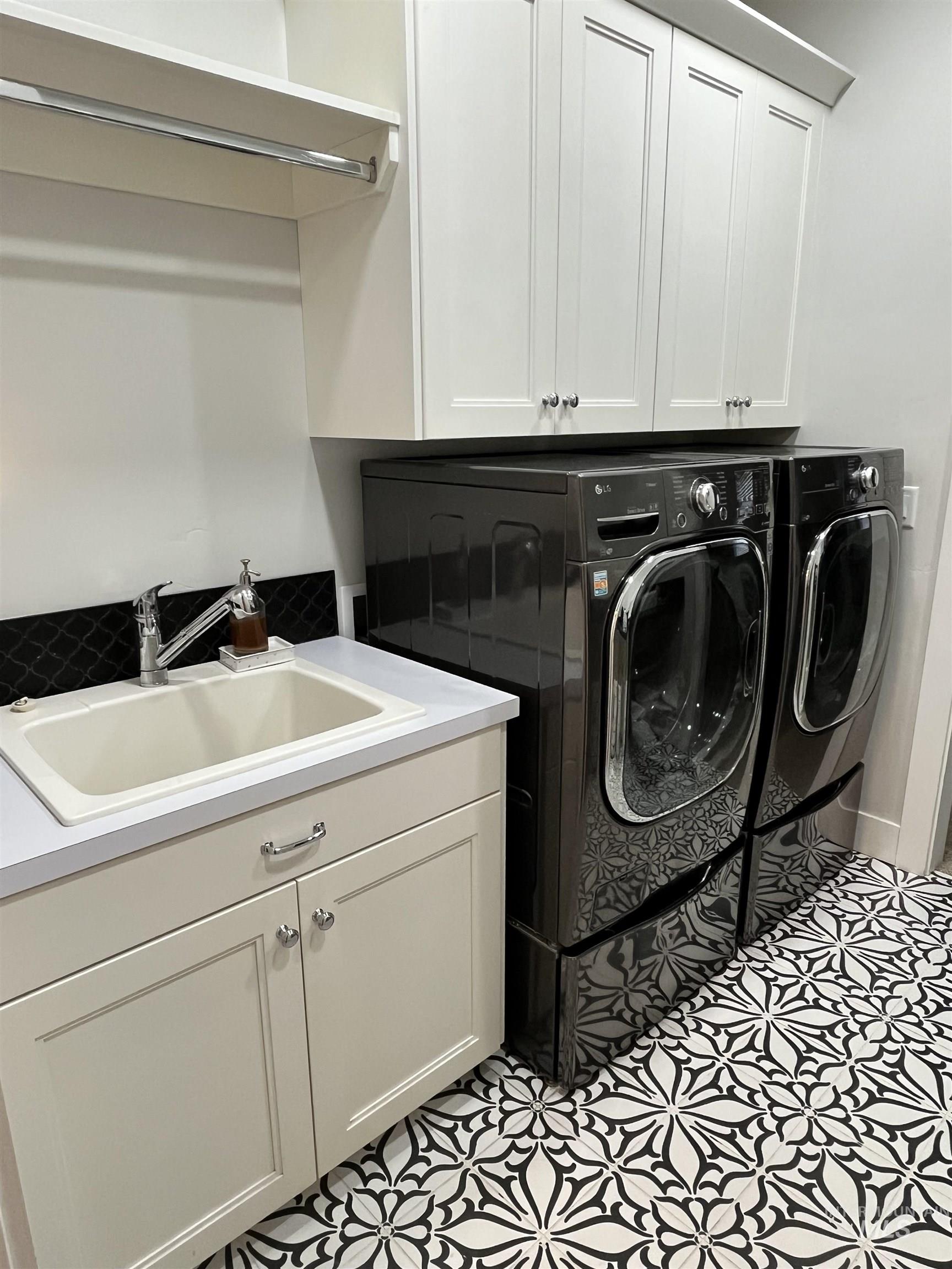 Laundry room featuring washer and dryer, cabinet space, and light floors