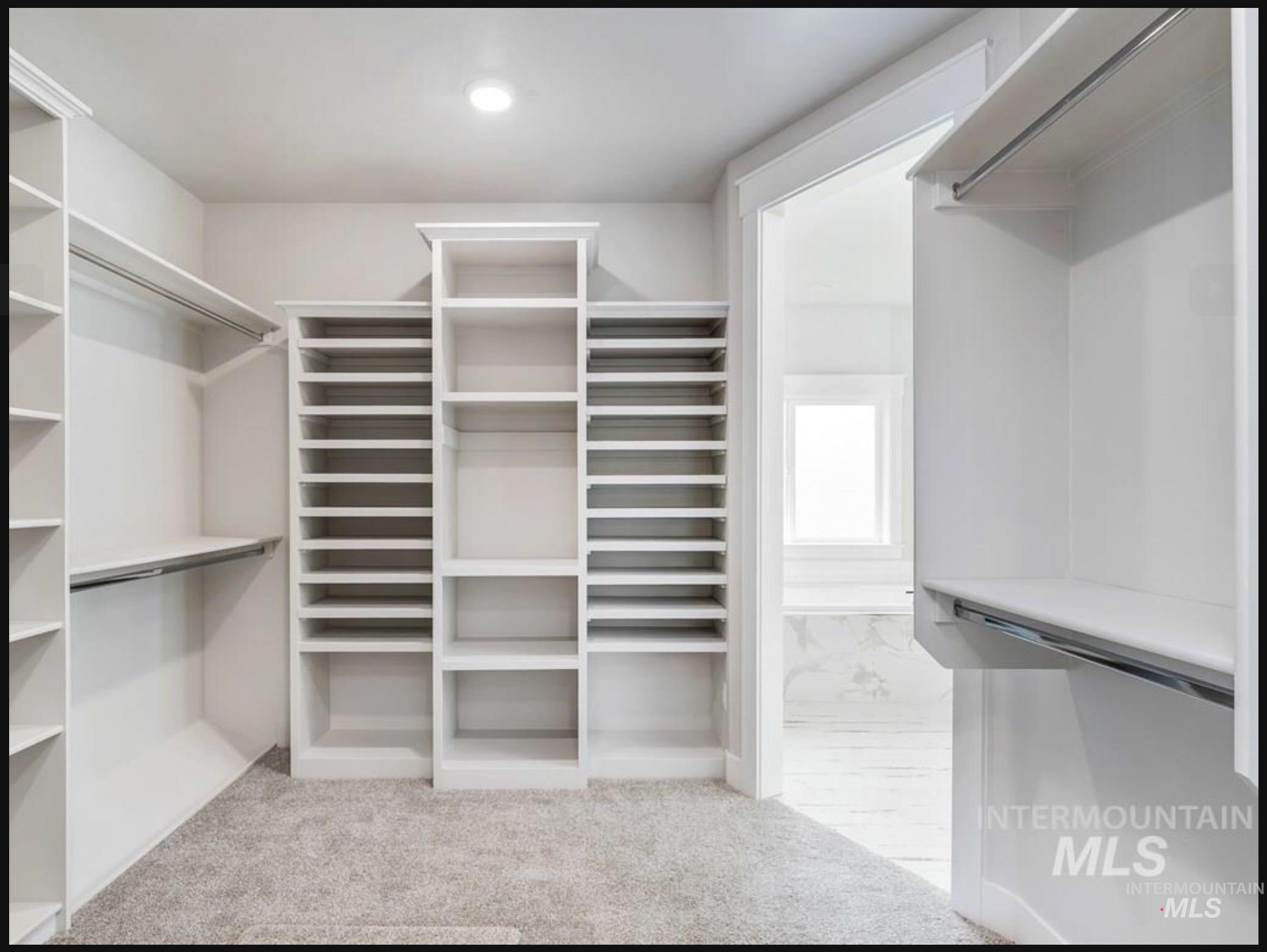 Walk in closet with custom shoe shelving.