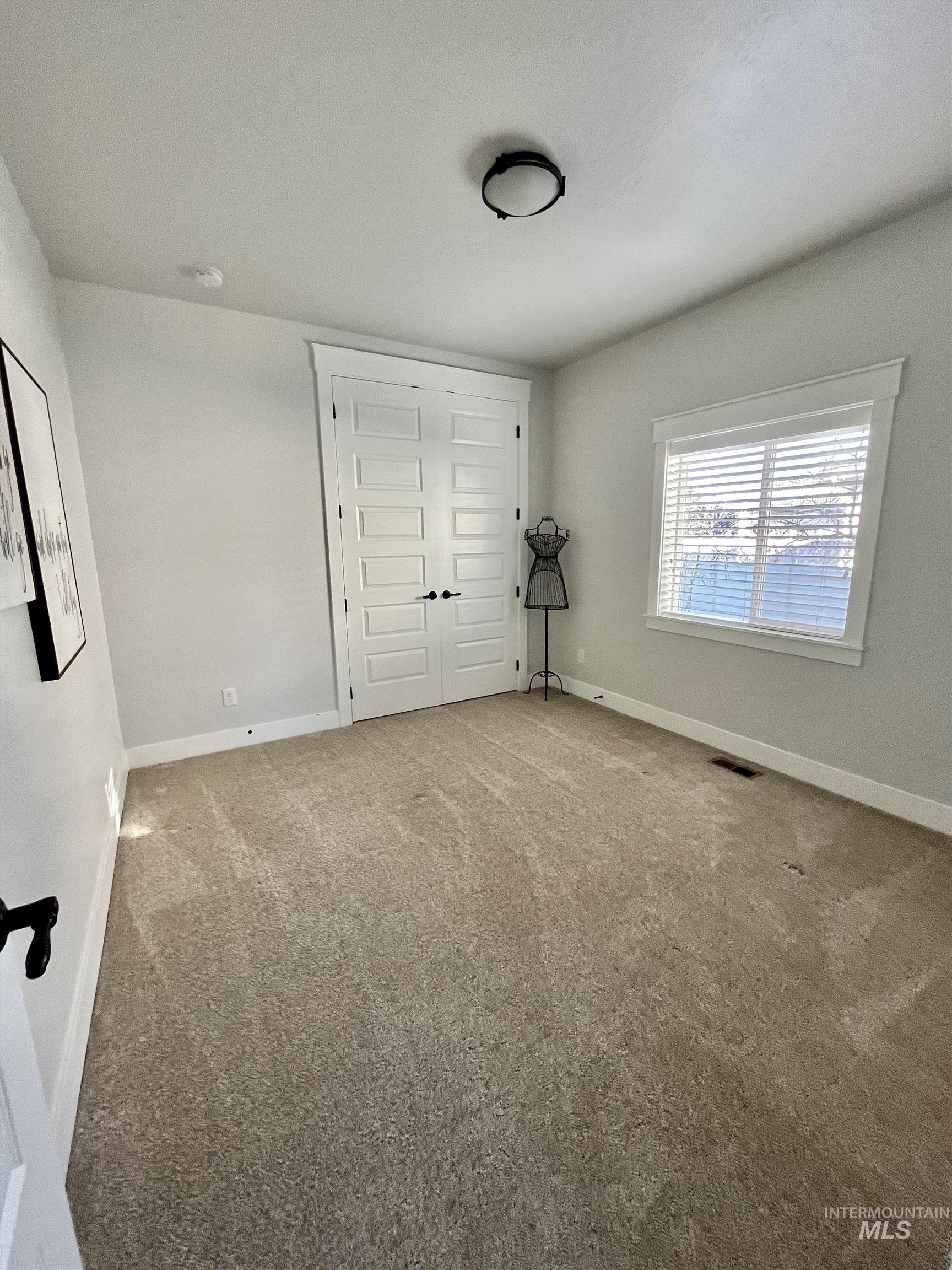 Unfurnished bedroom featuring baseboards and carpet floors