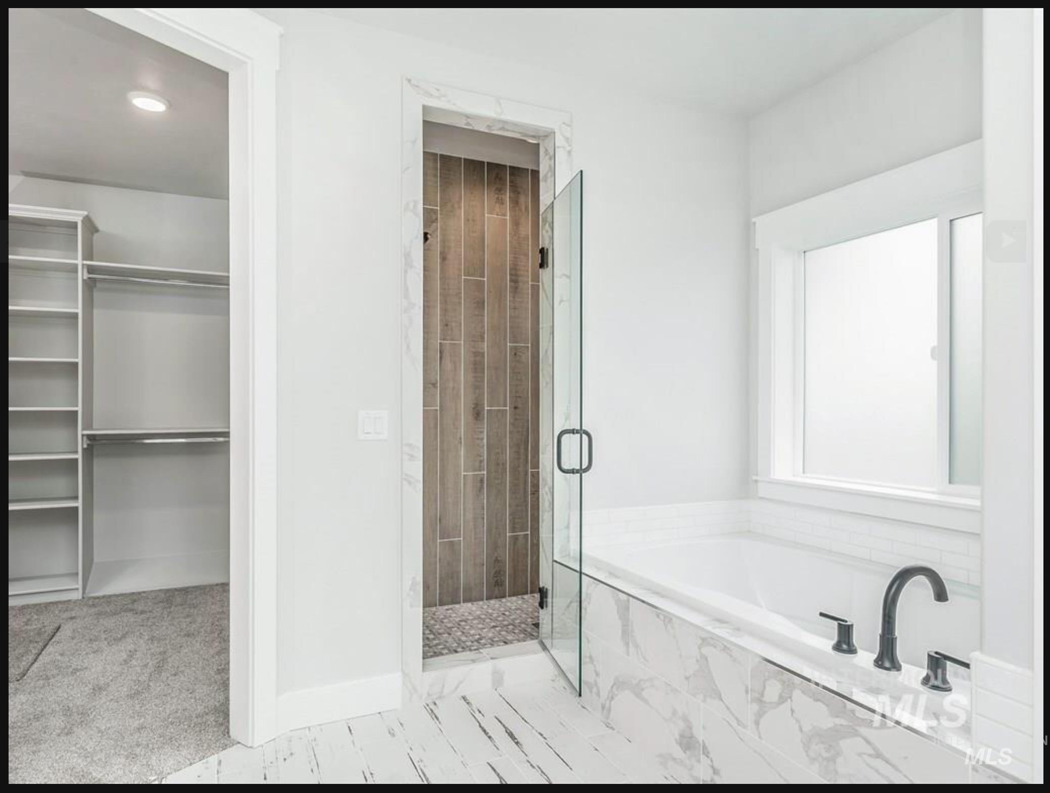 Full bathroom with a bath, a marble finish shower, and a walk in closet