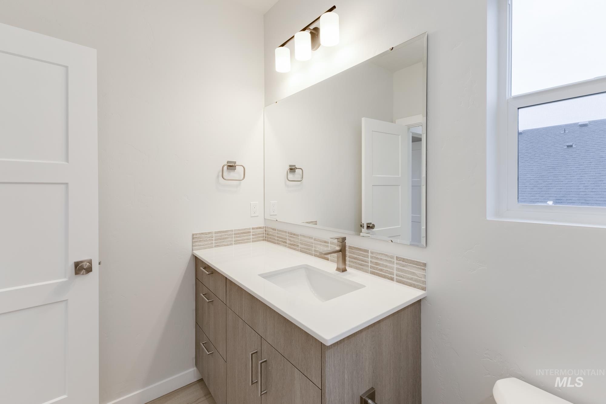 Bathroom with tasteful backsplash and vanity