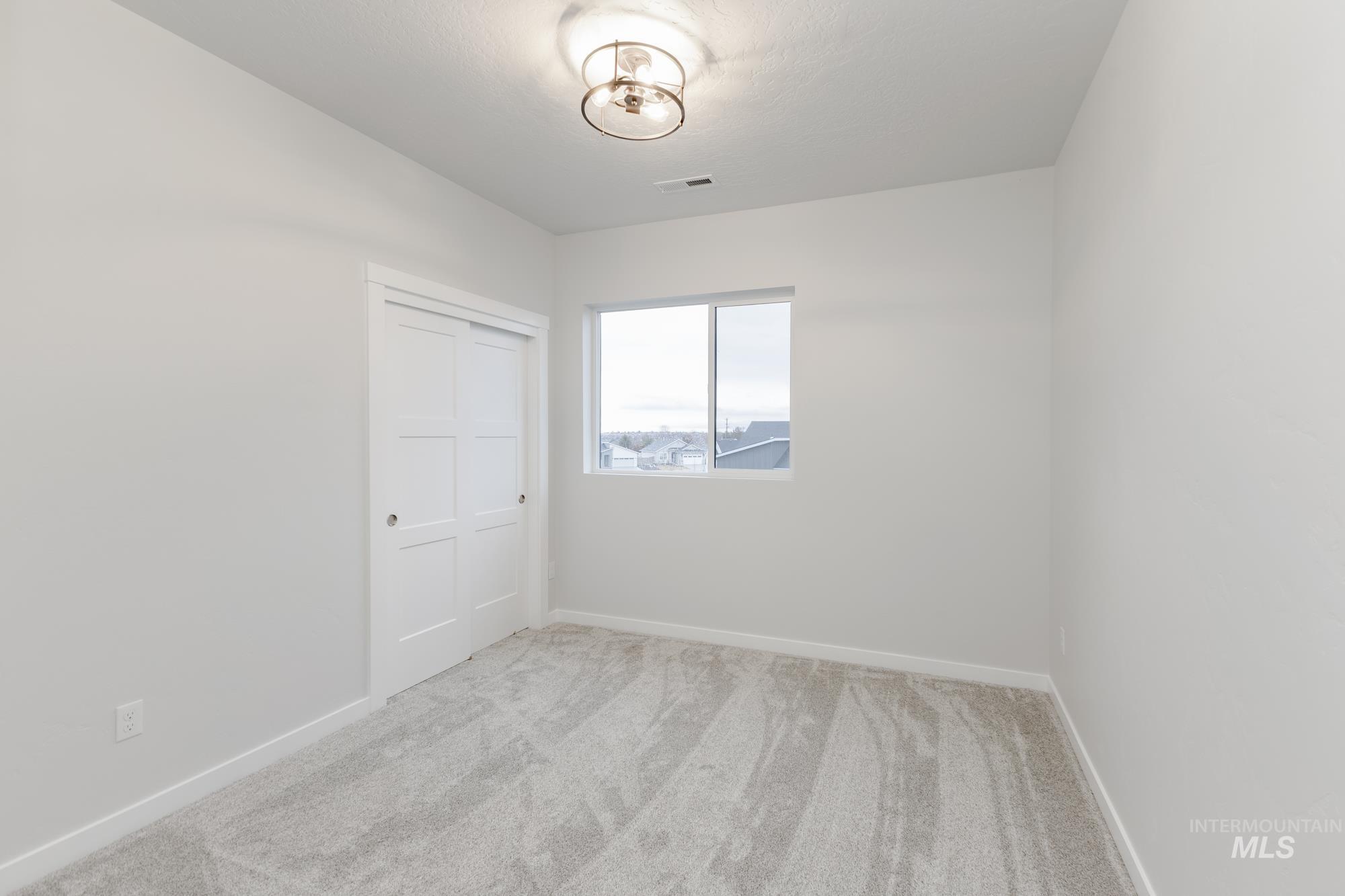 Unfurnished bedroom featuring light colored carpet and a closet