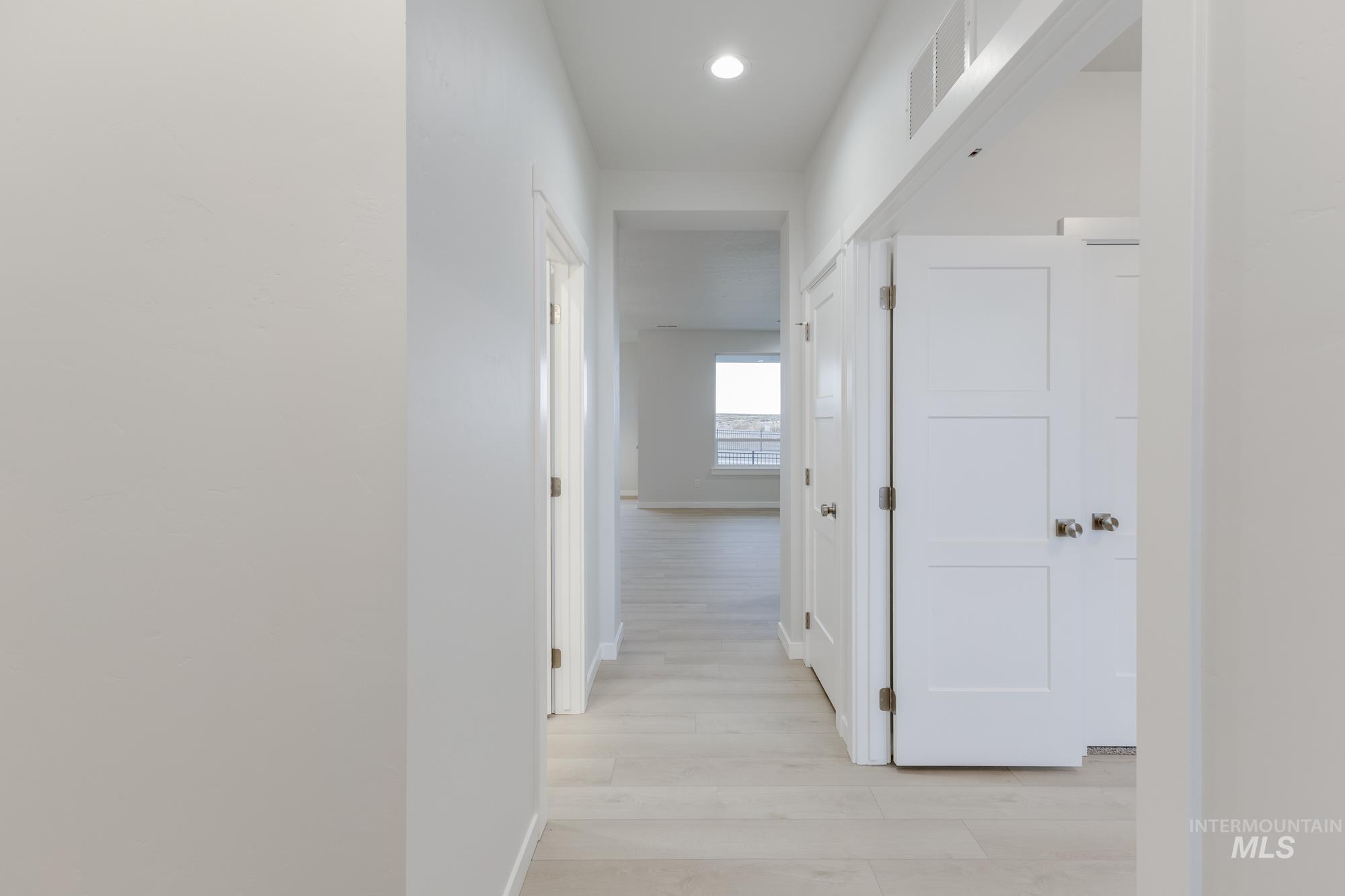 Corridor featuring light wood finished floors and recessed lighting