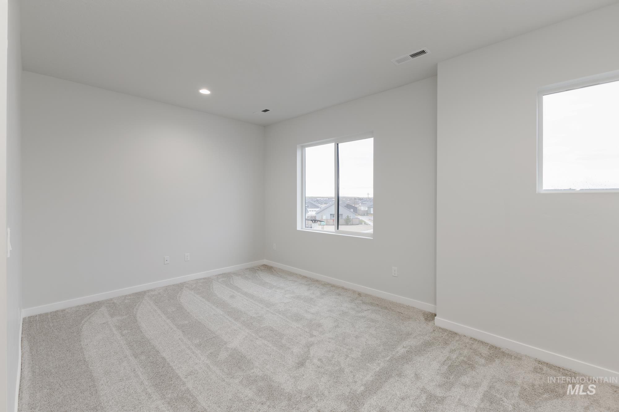 Spare room featuring light carpet and recessed lighting