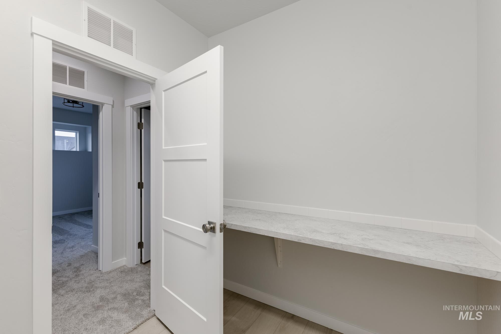 Corridor with baseboards and light colored carpet