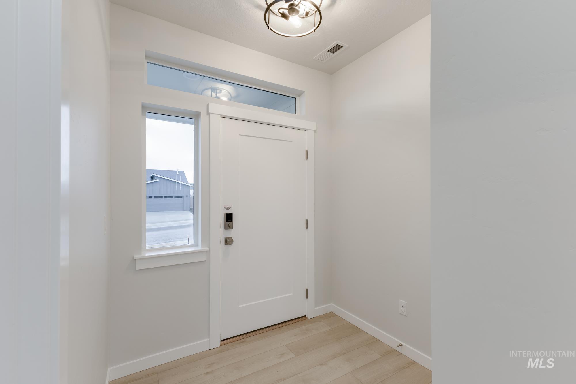 Foyer featuring light wood-style flooring and baseboards