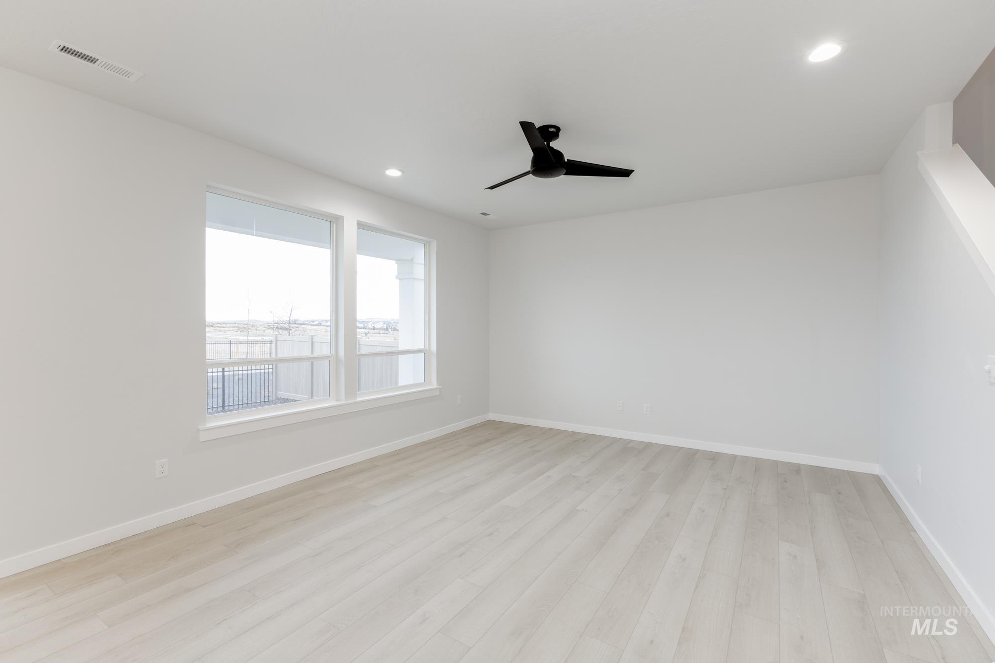 Spare room featuring light wood finished floors, a ceiling fan, and recessed lighting