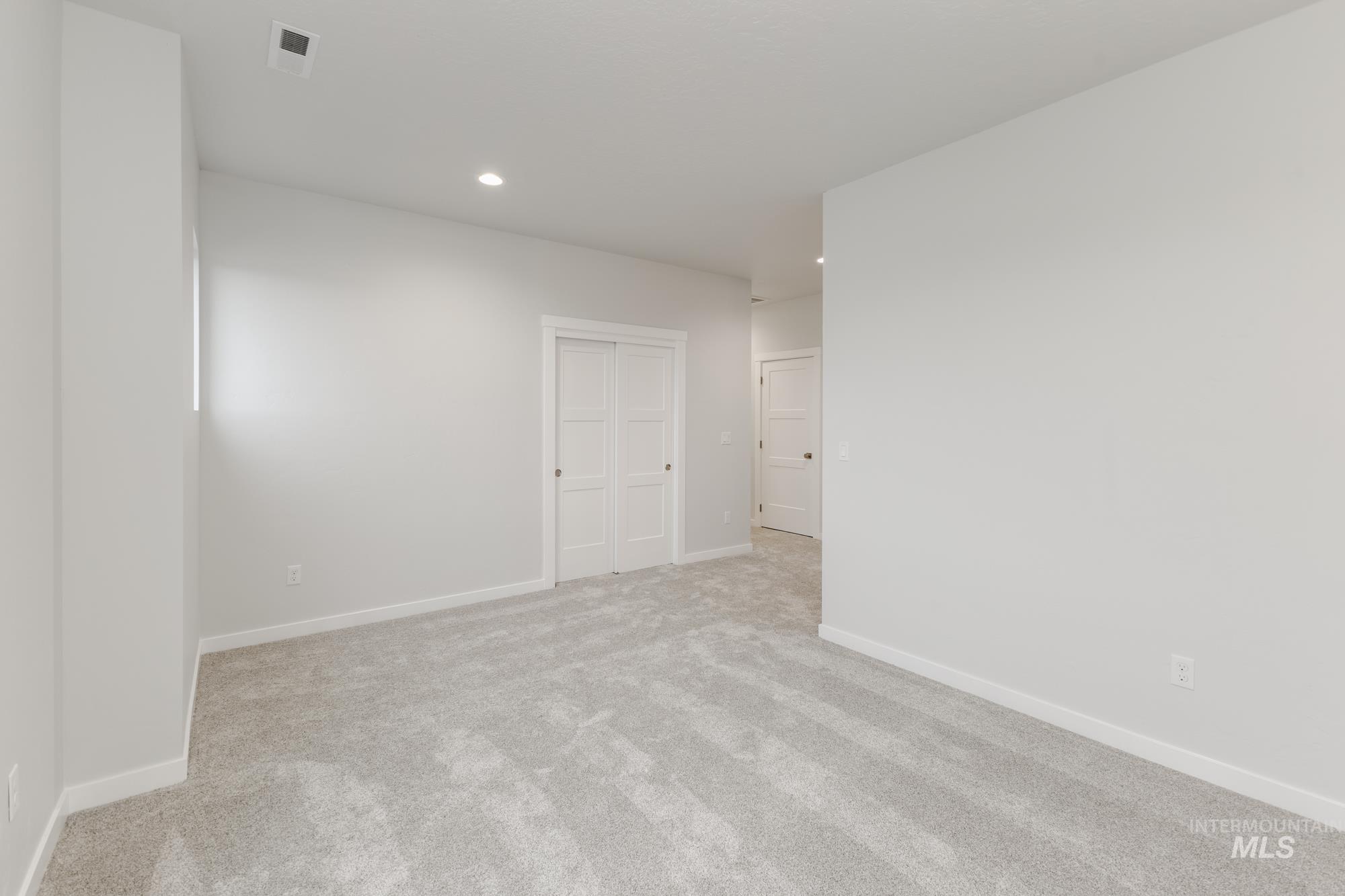Carpeted spare room featuring recessed lighting and baseboards