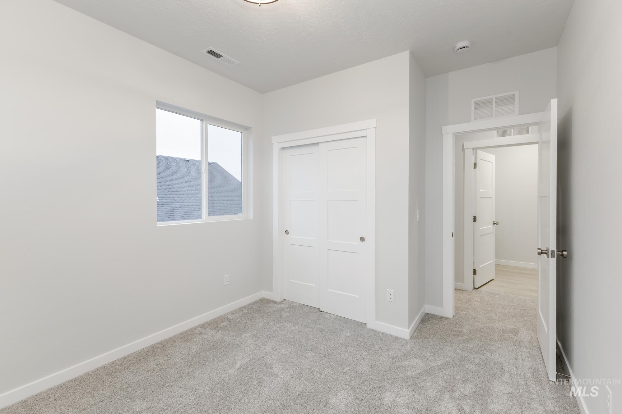 Unfurnished bedroom with a closet and light carpet