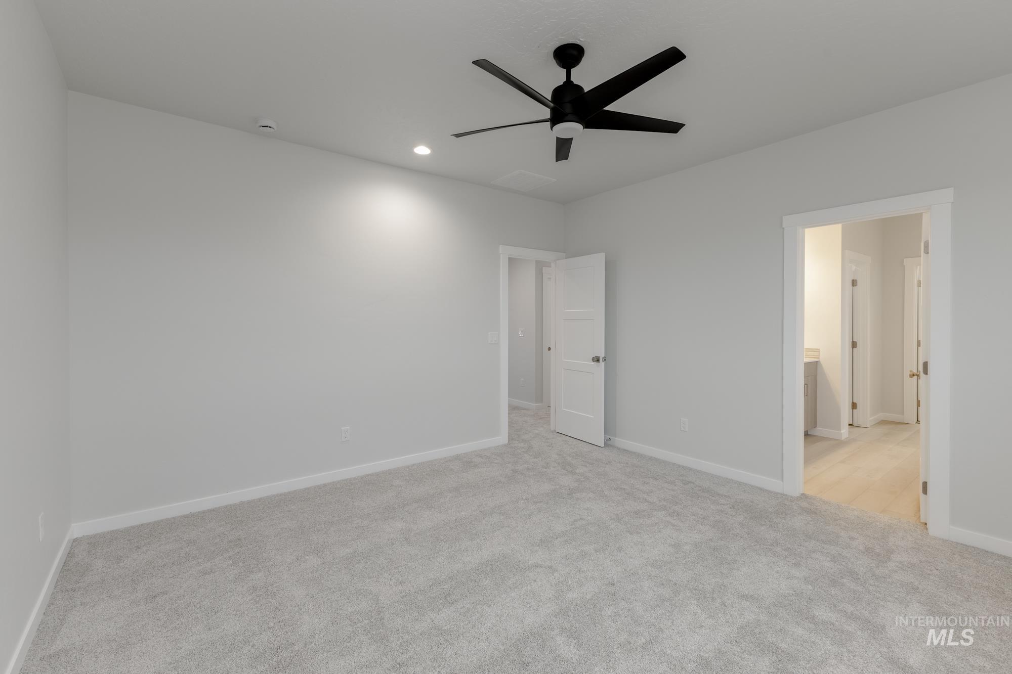 Unfurnished bedroom featuring light colored carpet, ceiling fan, recessed lighting, and connected bathroom