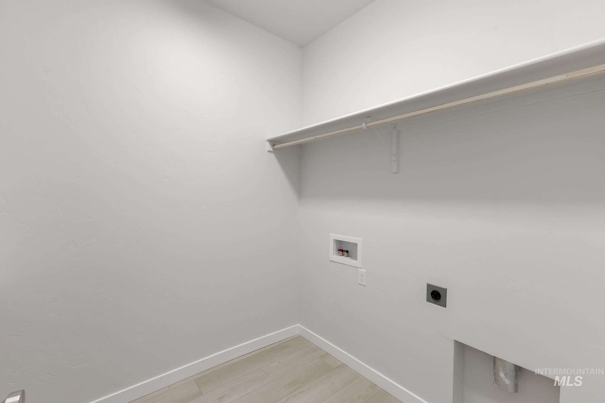 Laundry area featuring electric dryer hookup, washer hookup, and light wood-style flooring