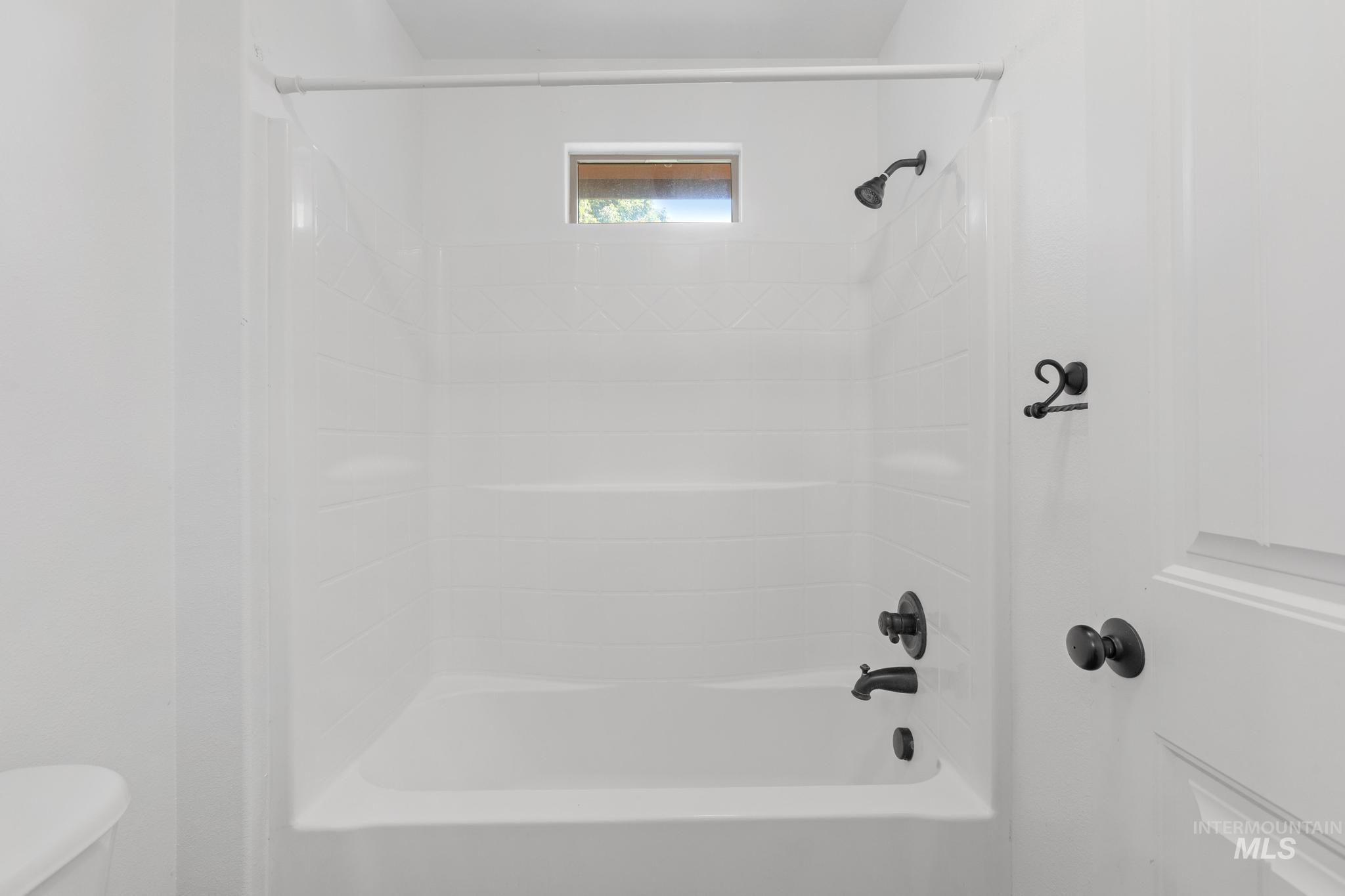 Full bathroom with toilet and washtub / shower combination
