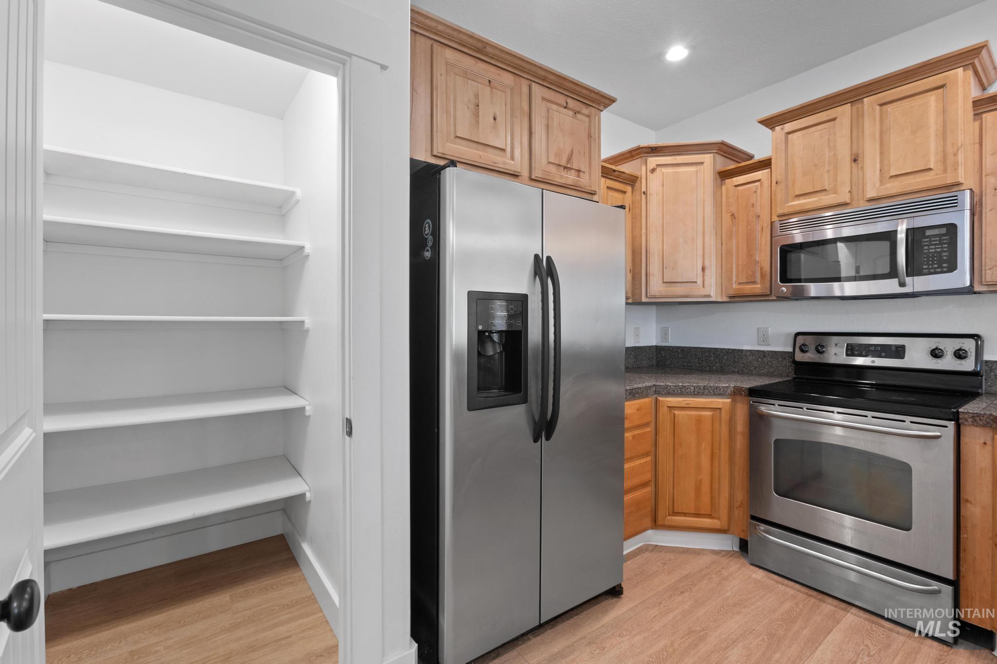 Kitchen featuring appliances with stainless steel finishes, light wood-style floors, light brown cabinets, and recessed lighting