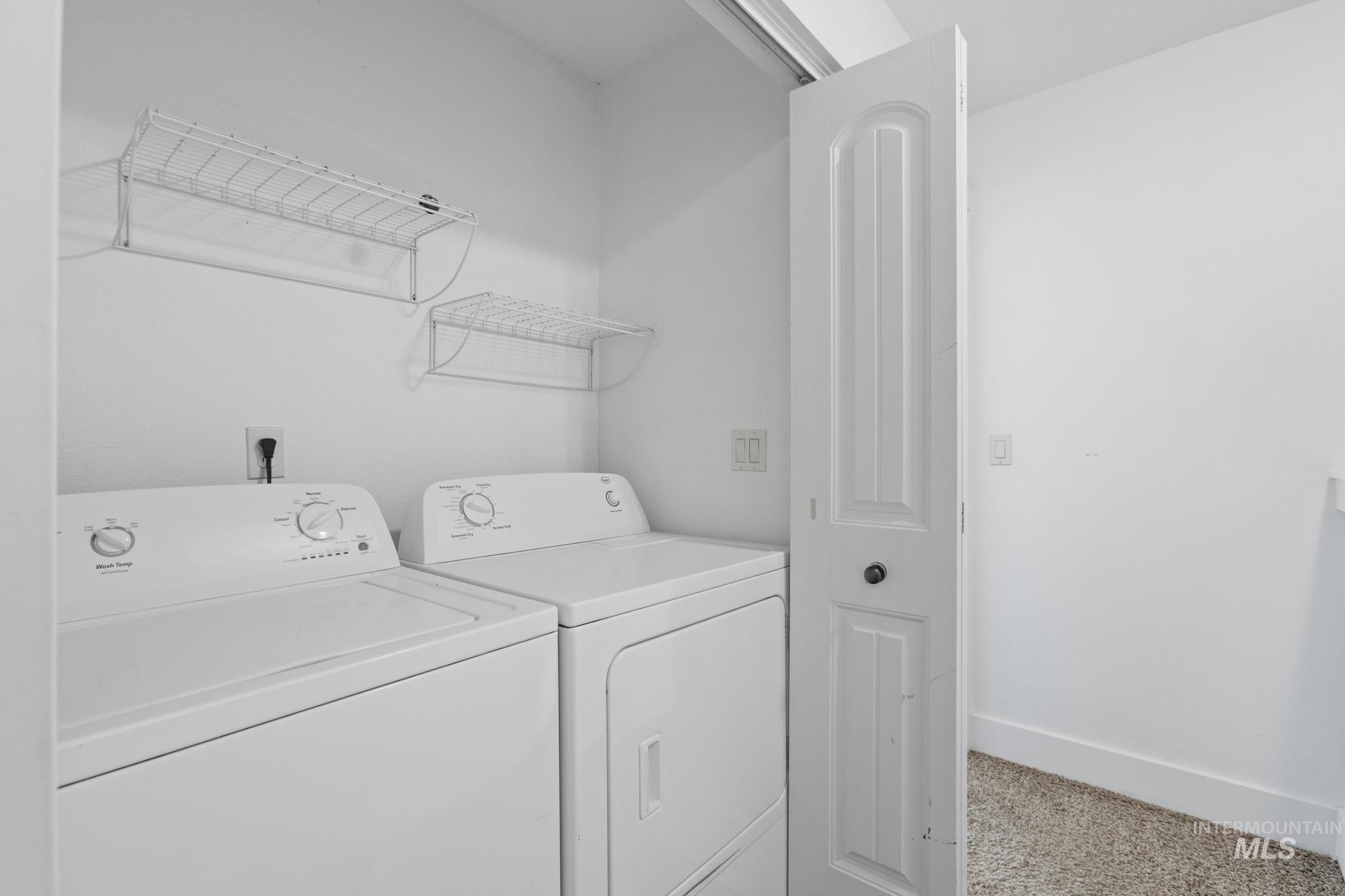 Laundry room with washer and dryer and baseboards