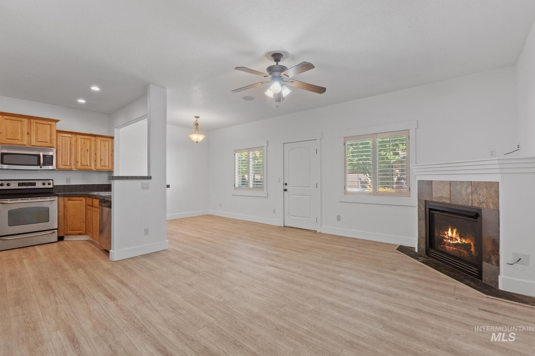 Kitchen featuring appliances with stainless steel finishes, open floor plan, light wood-type flooring, healthy amount of natural light, and recessed lighting