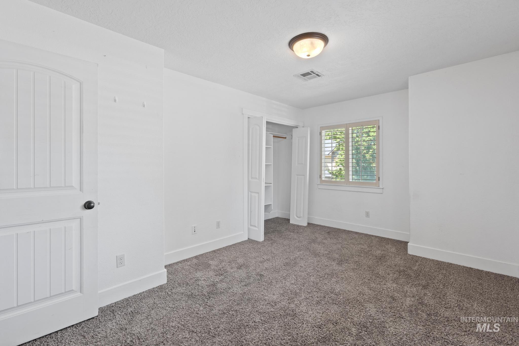 Unfurnished bedroom with carpet, a closet, and a textured ceiling