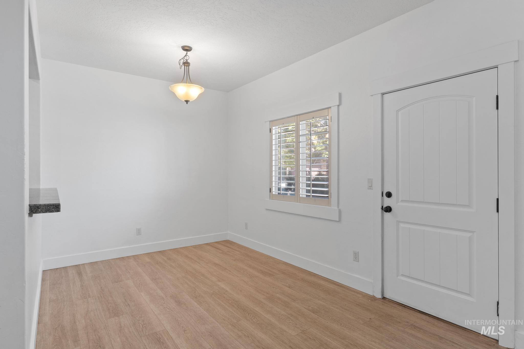 Foyer with light wood finished floors and baseboards