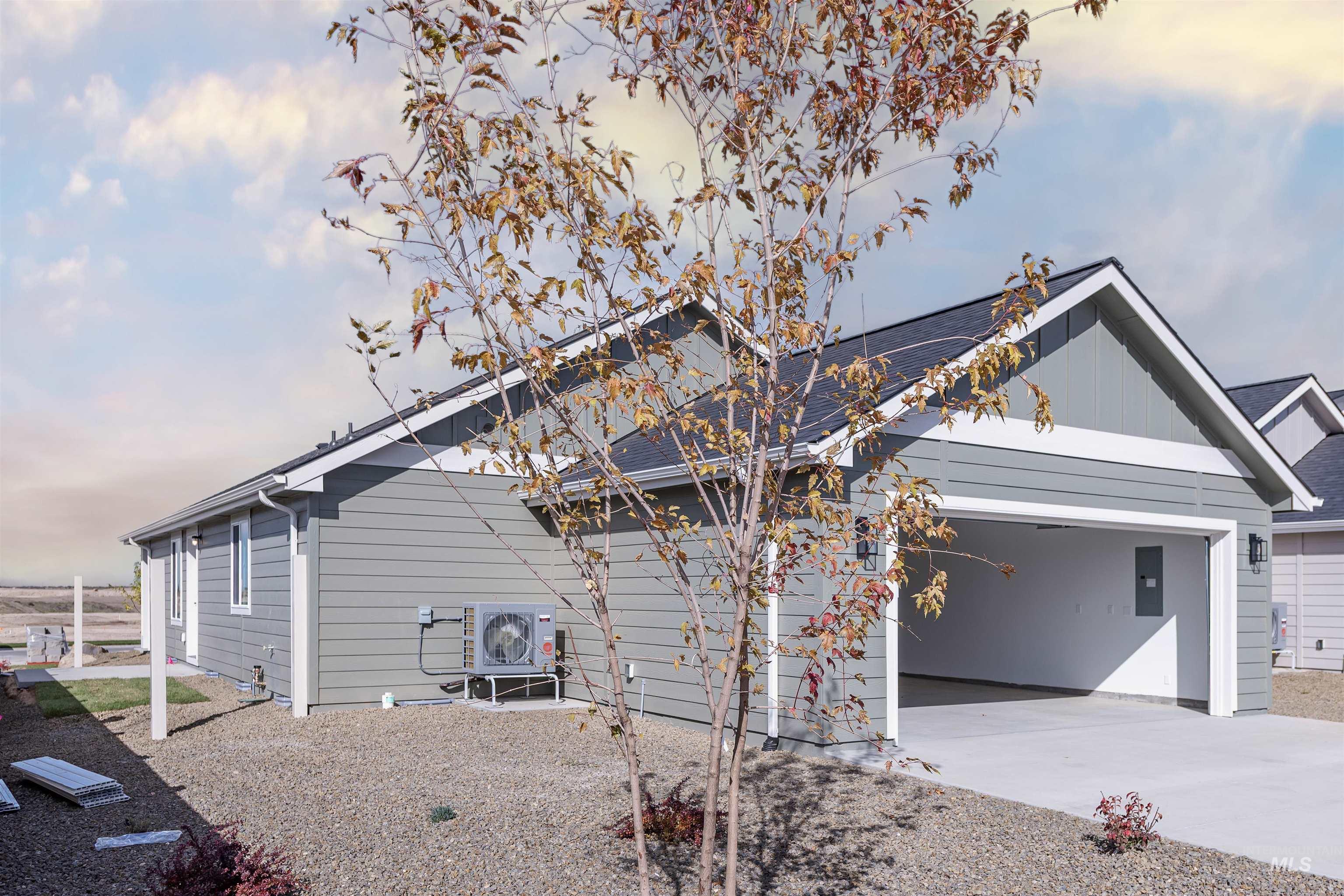 View of home's exterior featuring board and batten siding, driveway, an attached garage, and a shingled roof