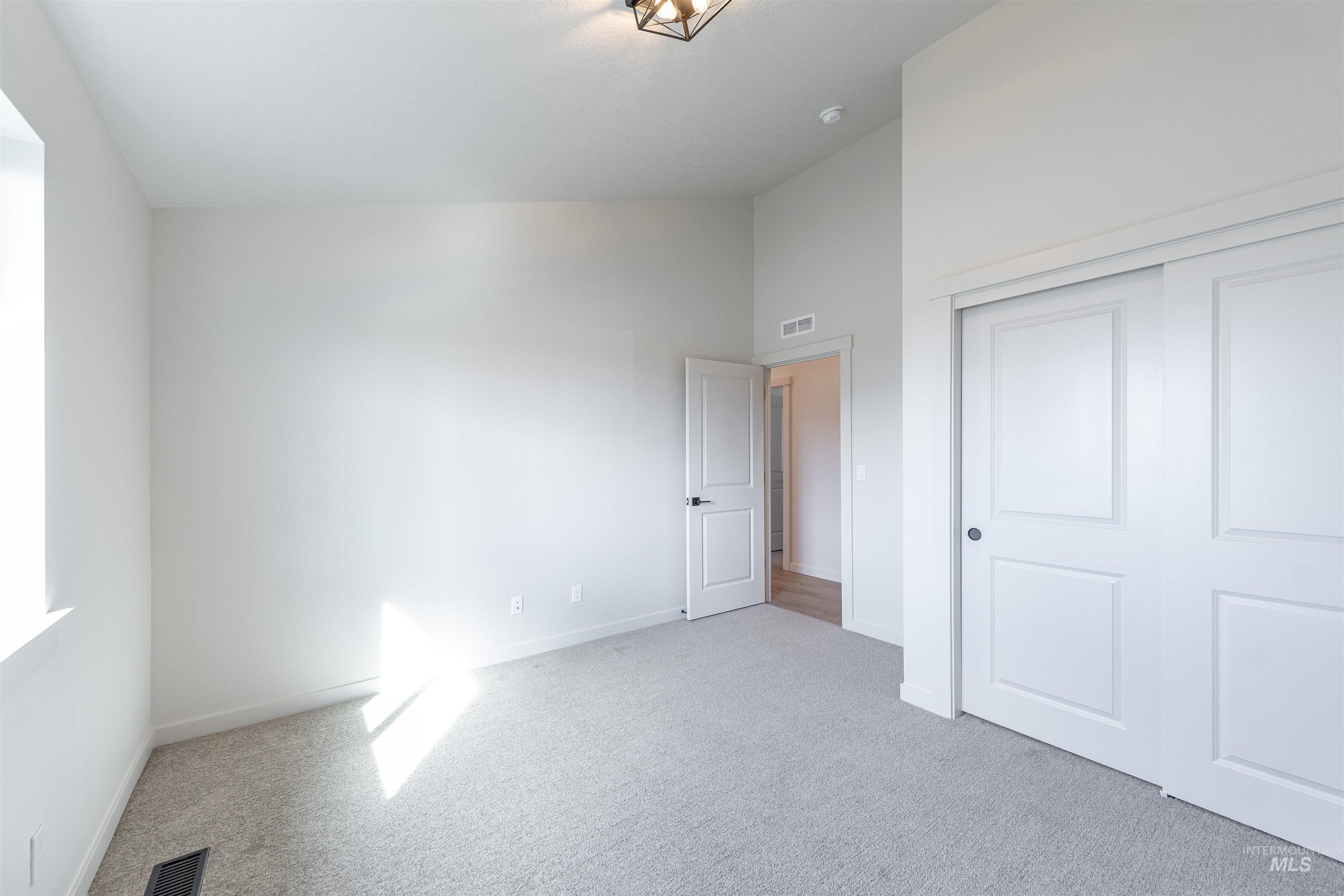 Unfurnished bedroom with light colored carpet and a closet