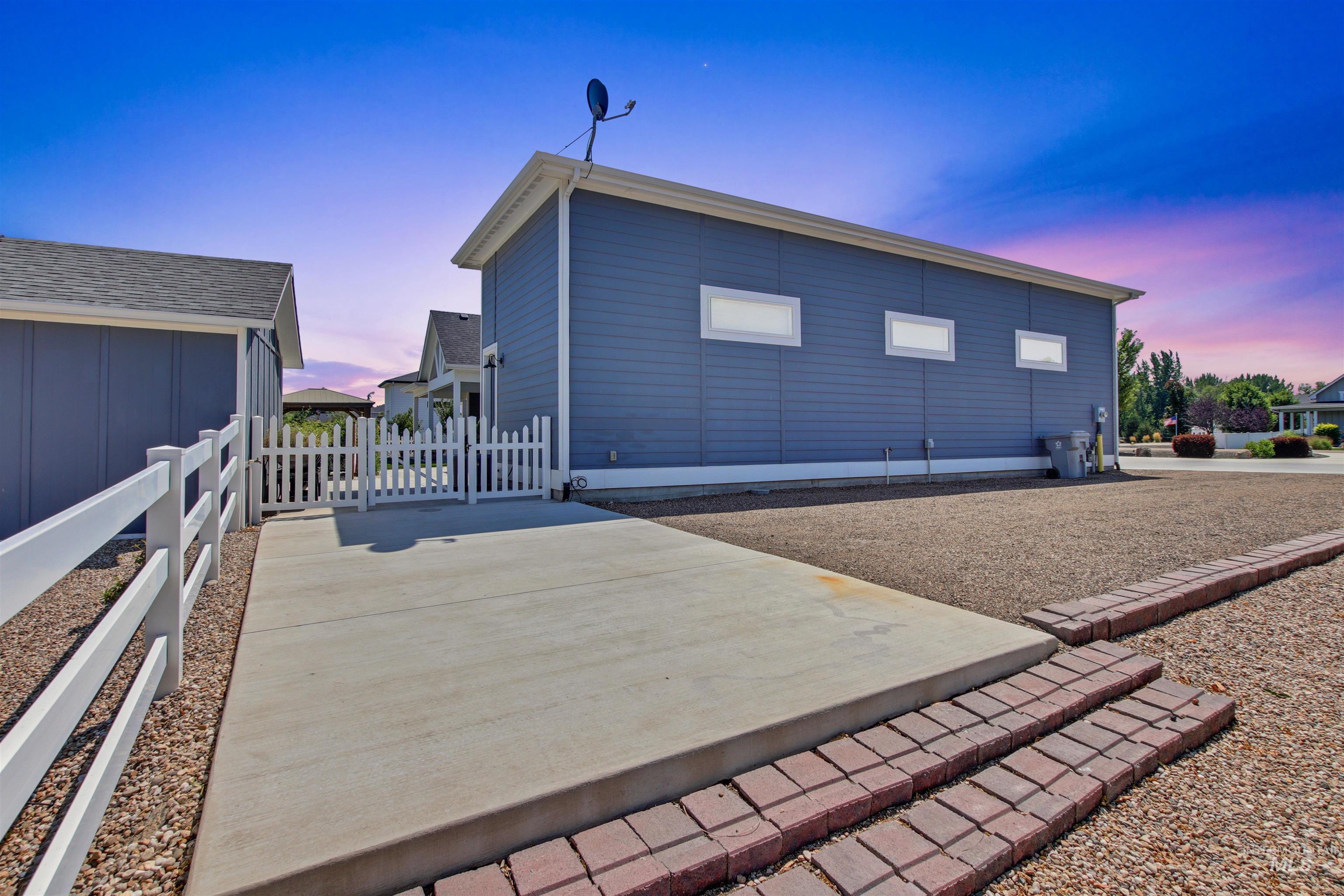 Back of house at dusk with a patio area and a gate