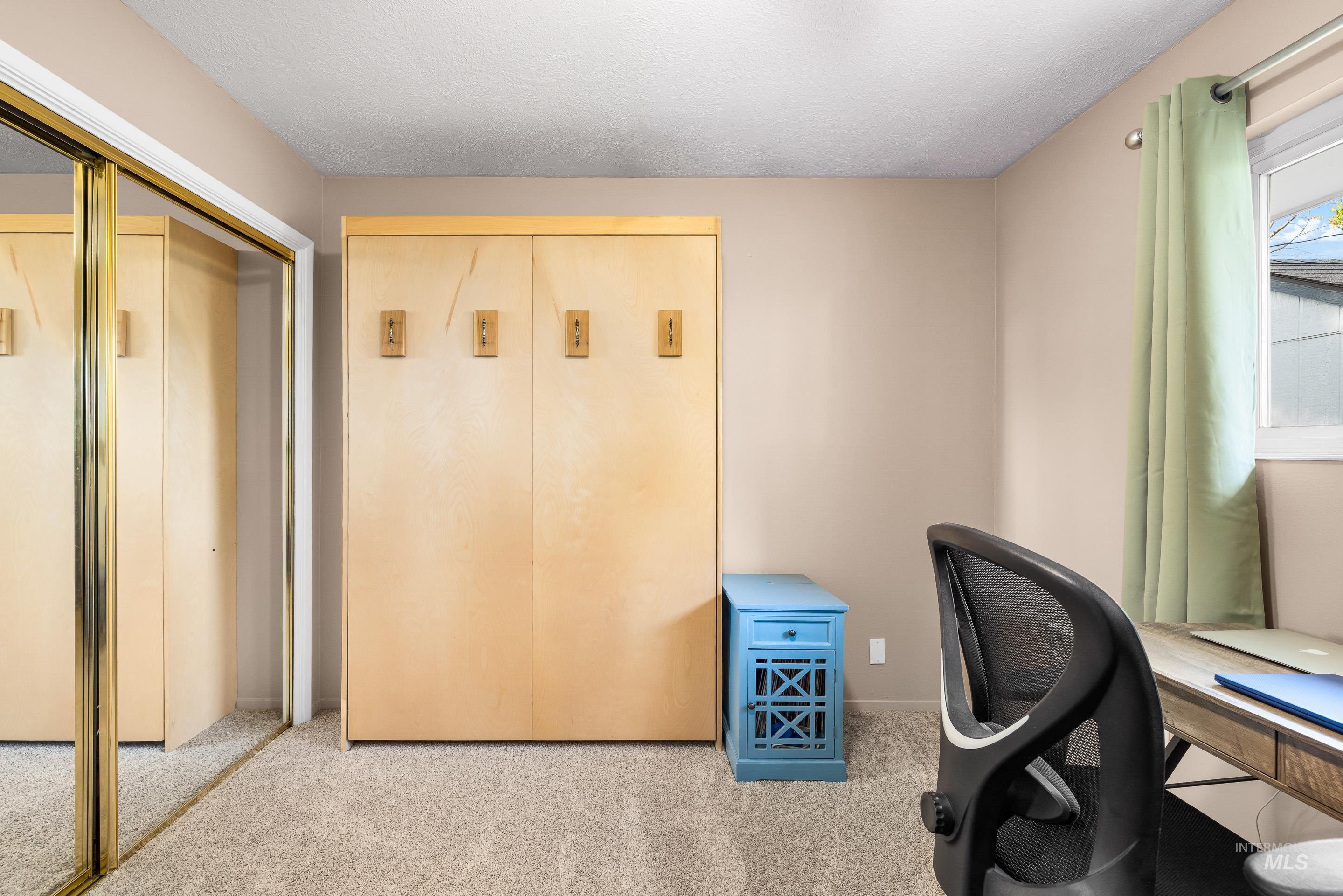 Home office with carpet flooring and a textured ceiling