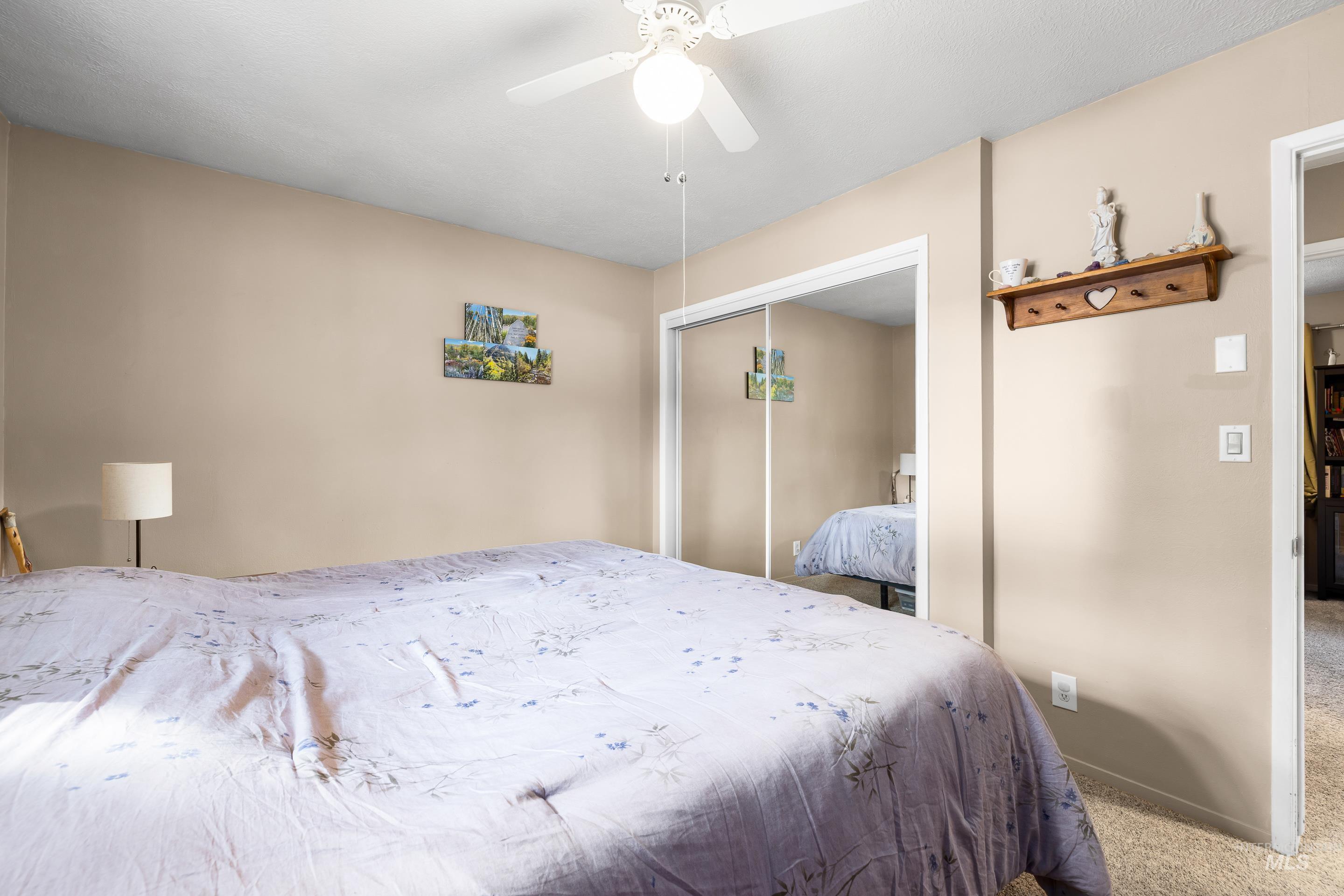 Carpeted bedroom featuring a closet and a ceiling fan