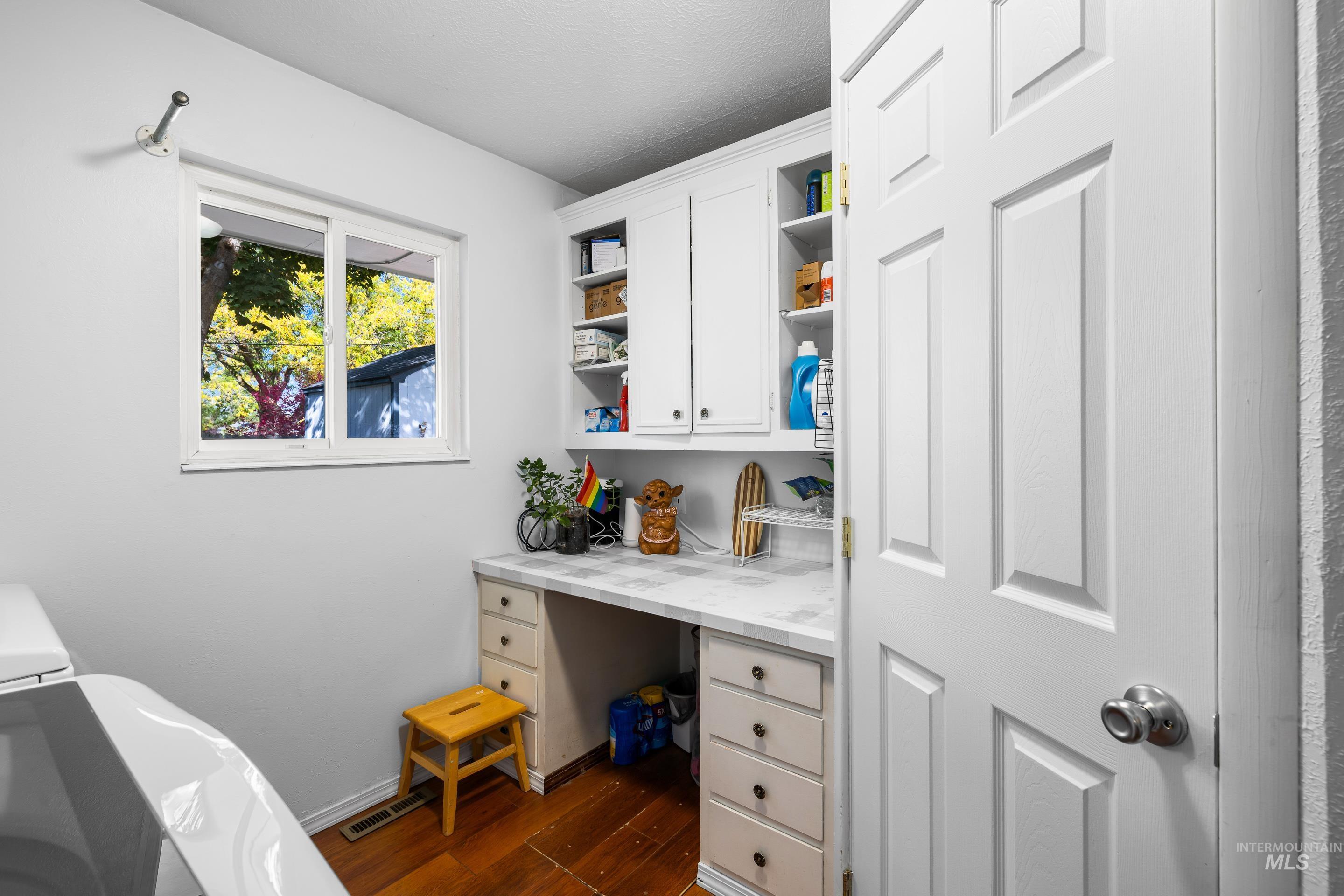 Office area with built in study area and dark wood-style flooring