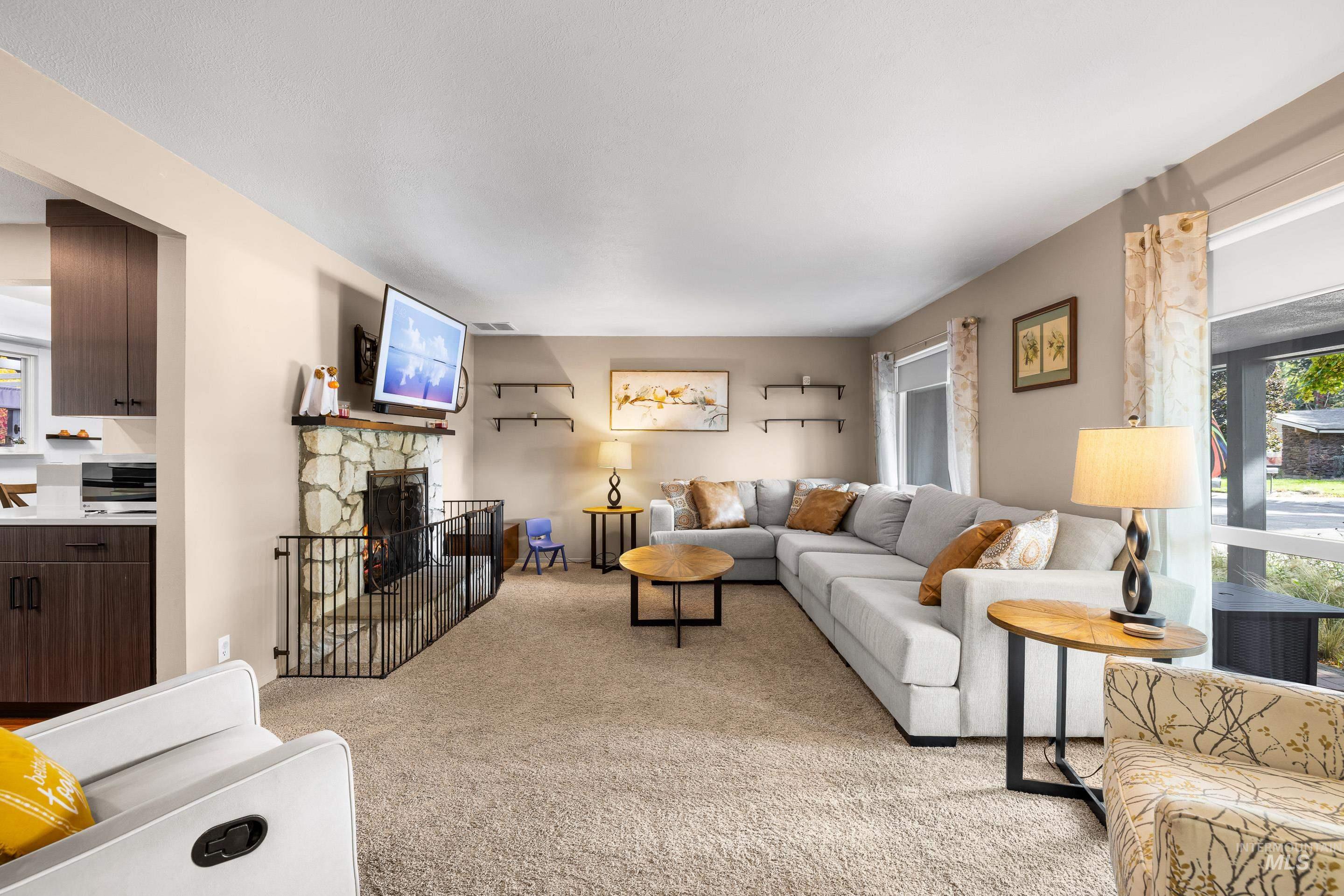 Living area with light colored carpet and a fireplace