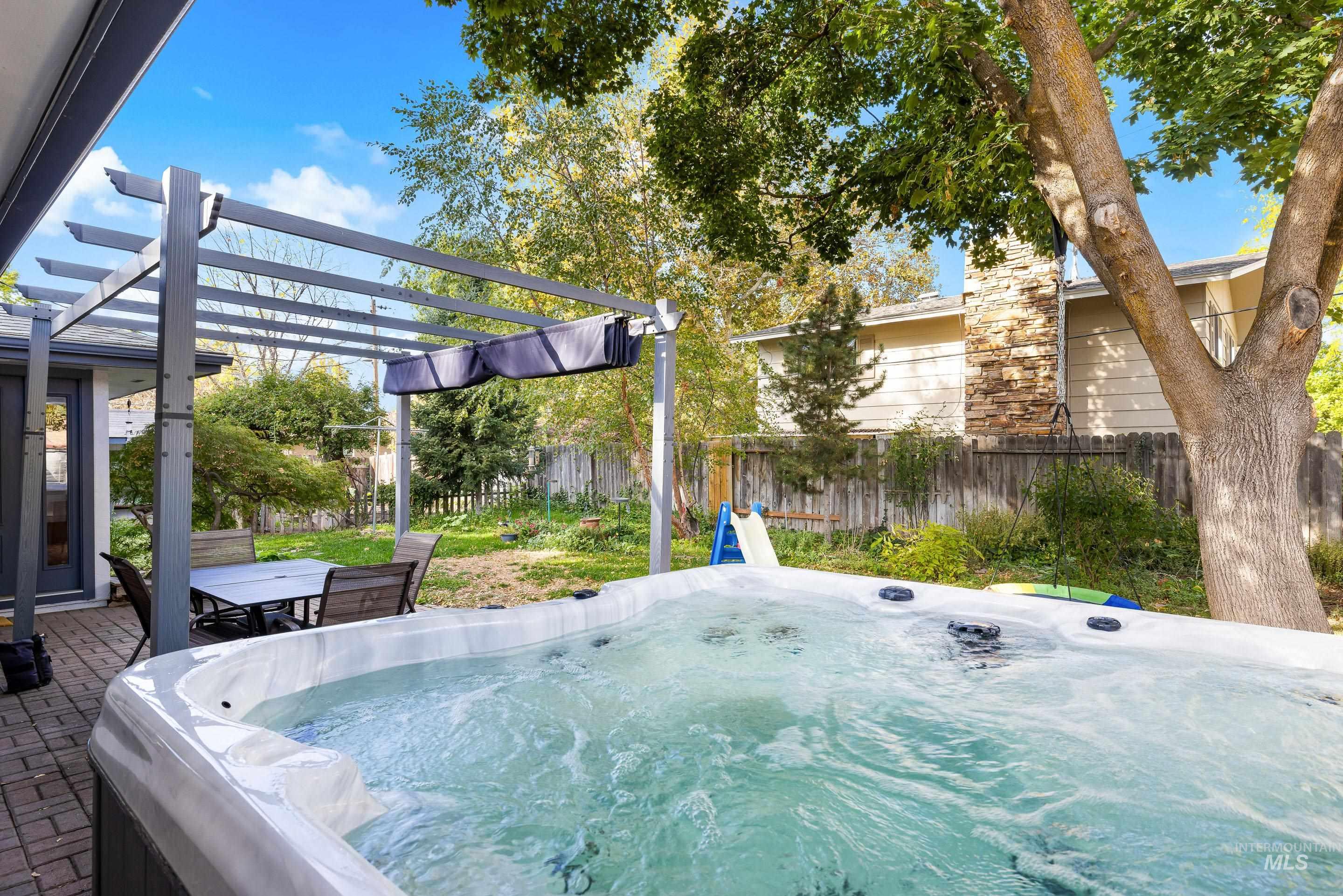 View of community with a pergola, a jacuzzi, and a patio area