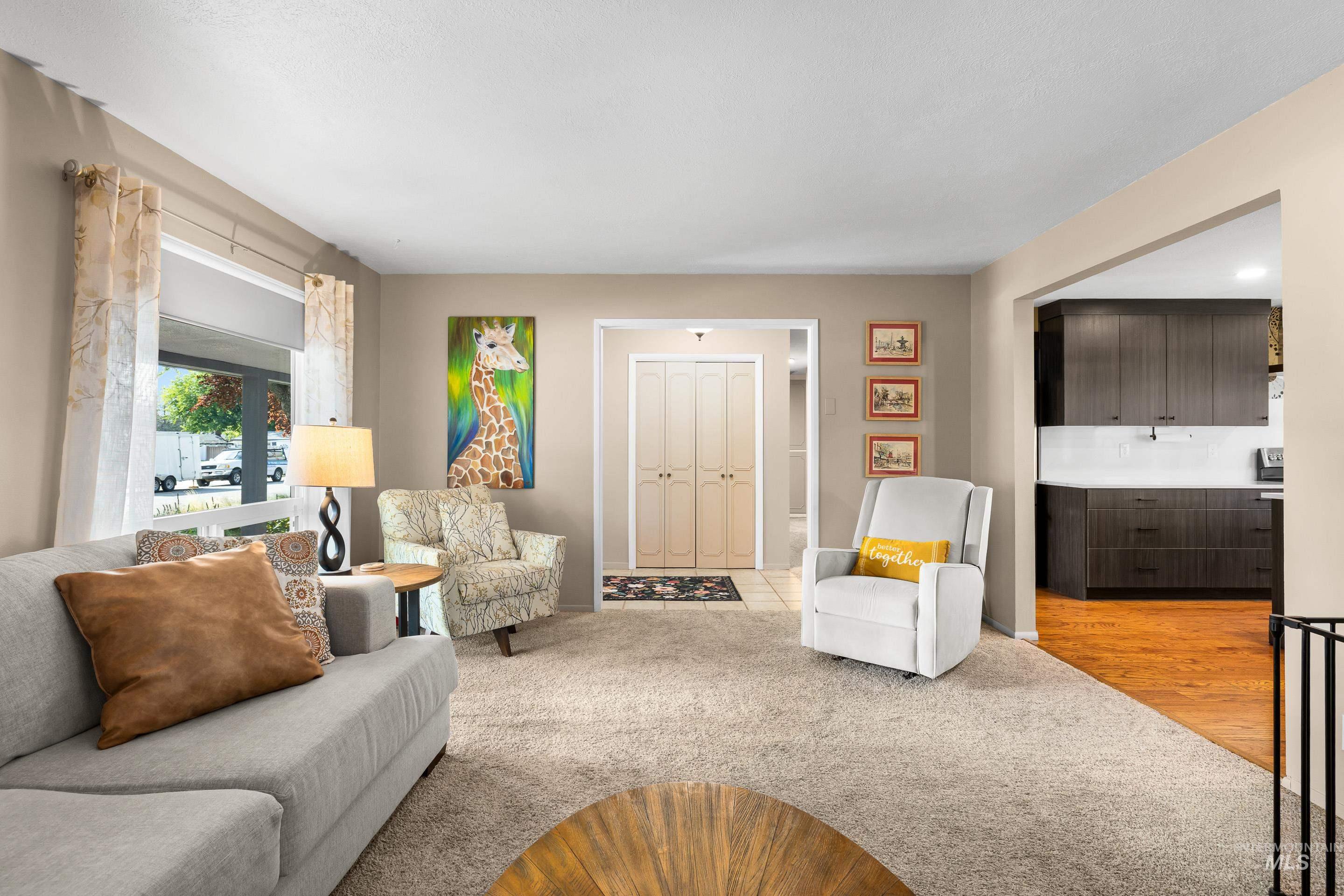 Living area with light colored carpet and light wood-style floors